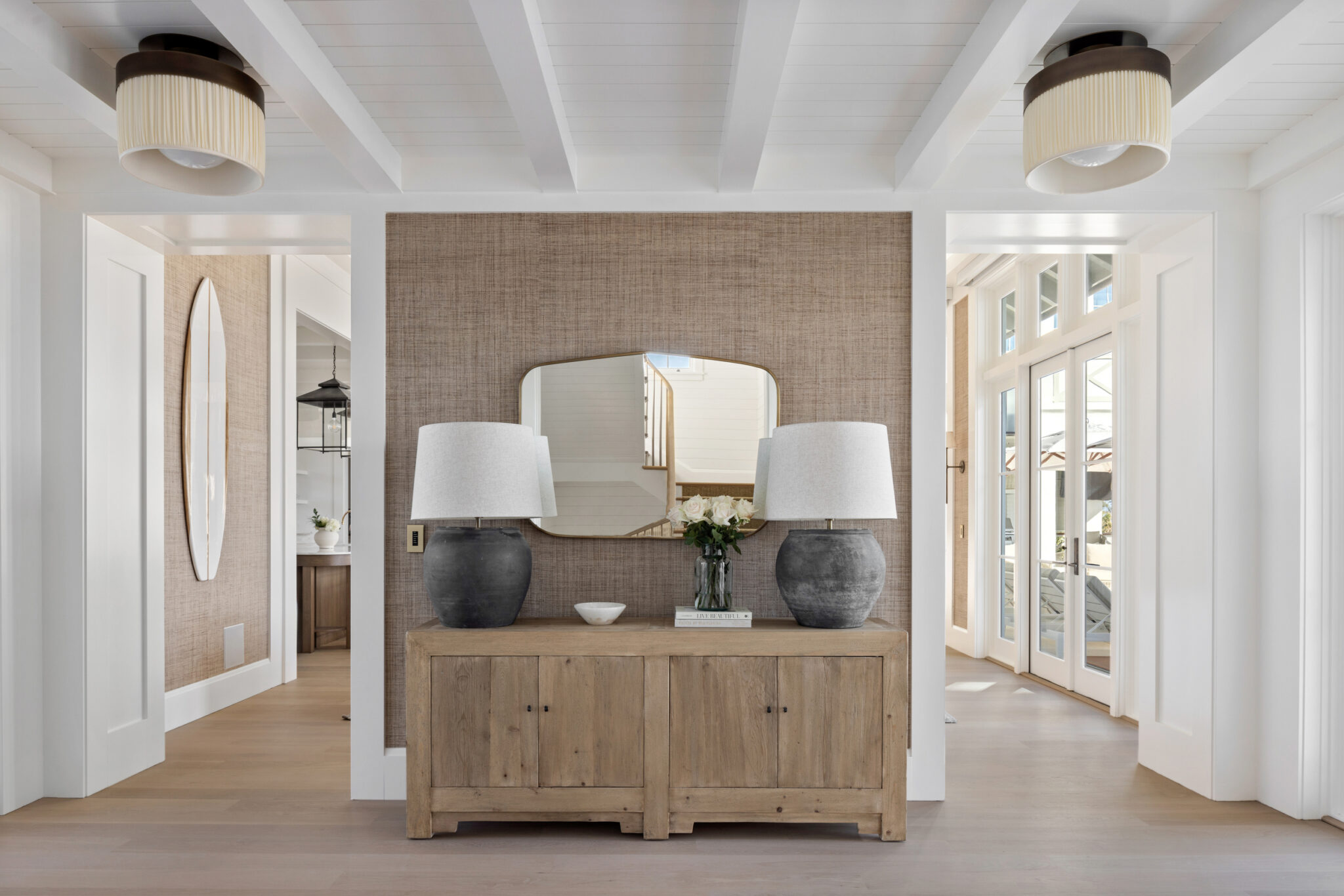 Entry hall with an oak console, twin lamps and a round mirror