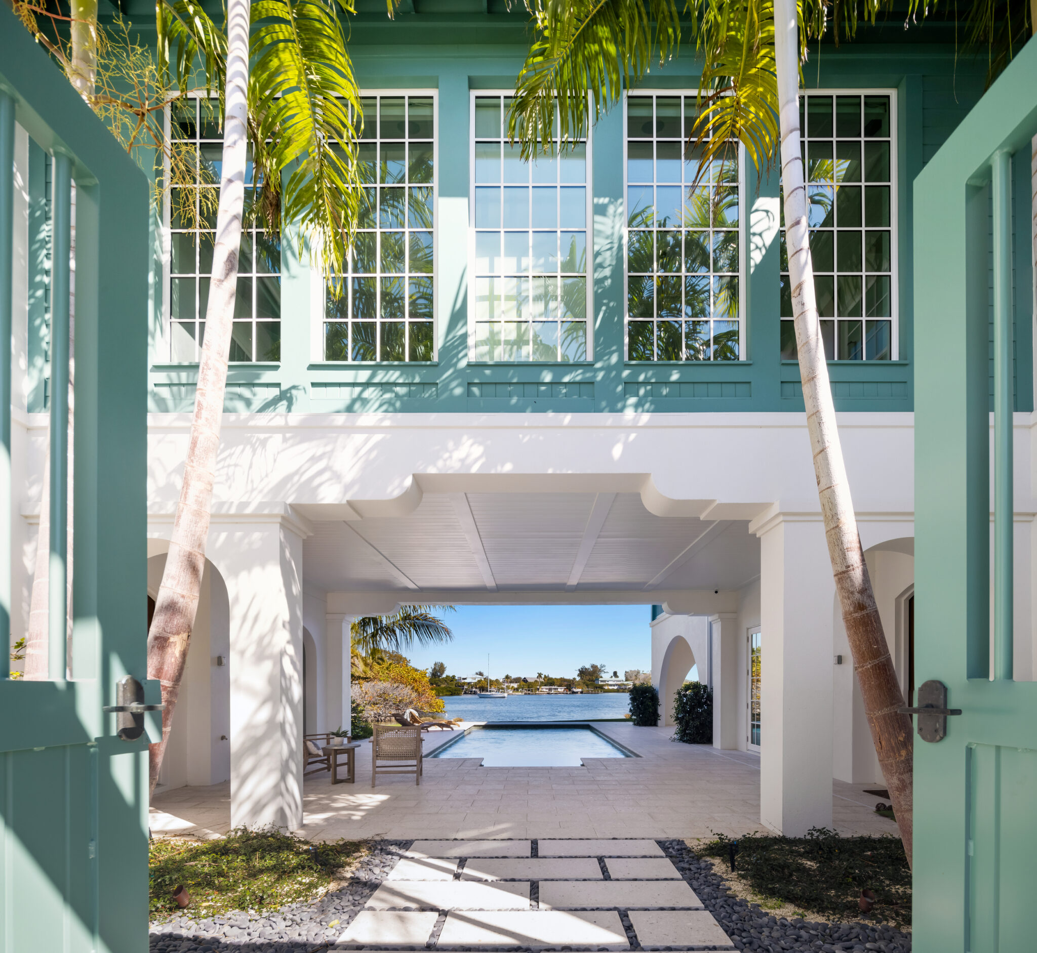 View through green French doors into the courtyard and pool