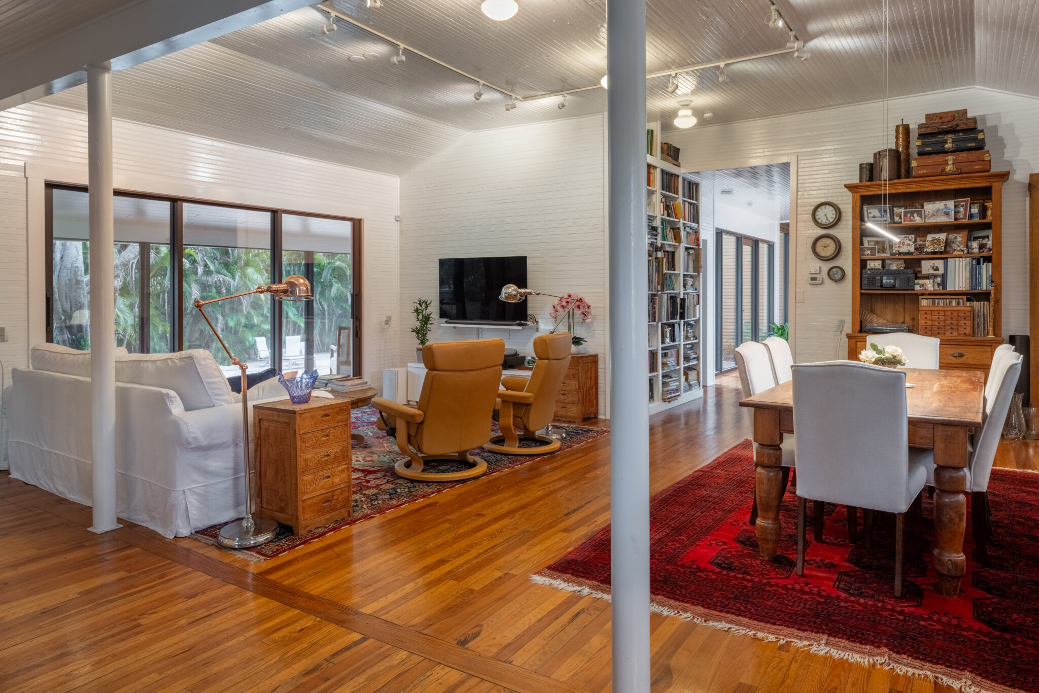 Living and dining room in the original schoolhouse with wood floors and built-in shelves