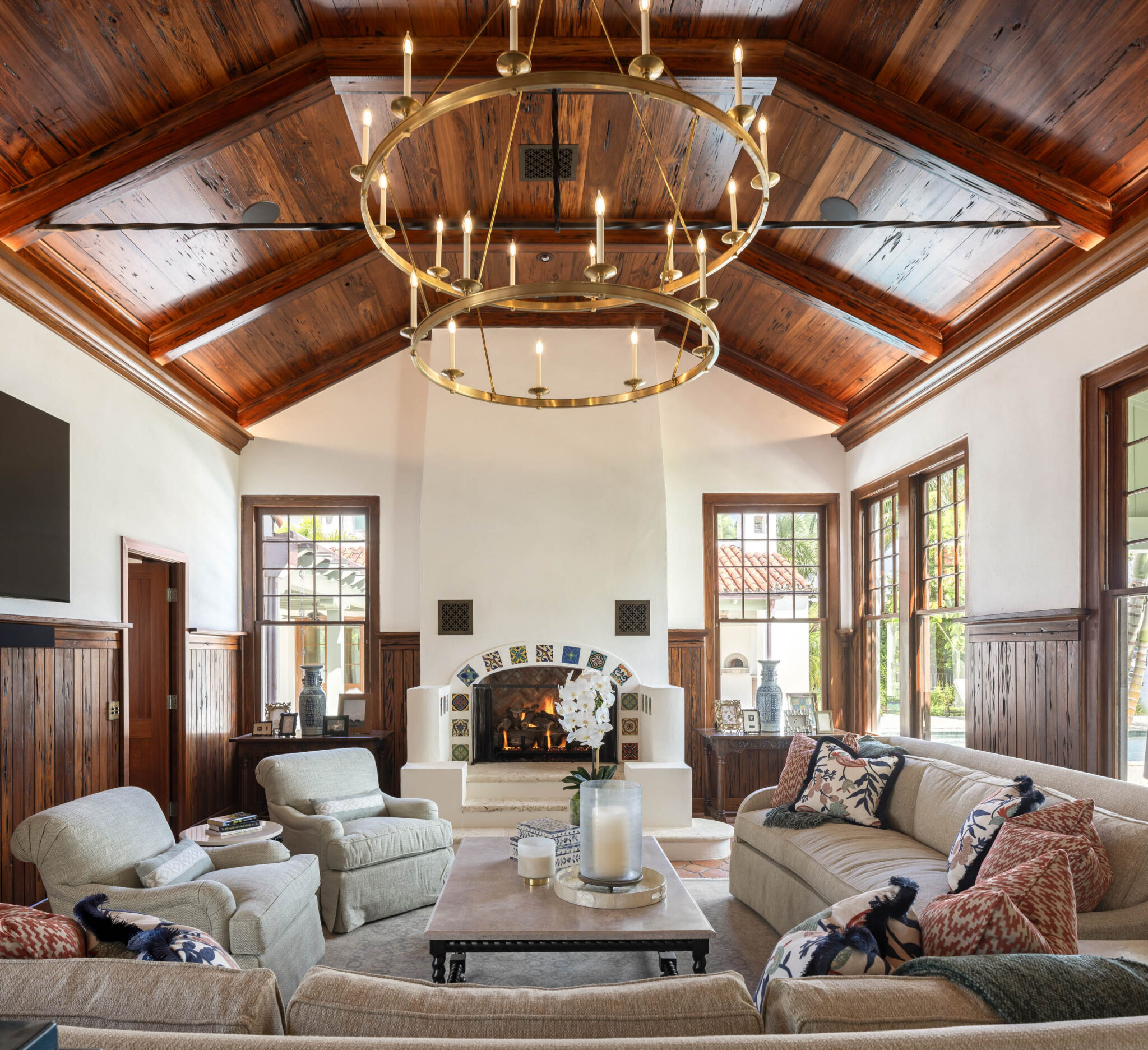Great room with a stained beamed ceiling, brass chandelier and fireplace