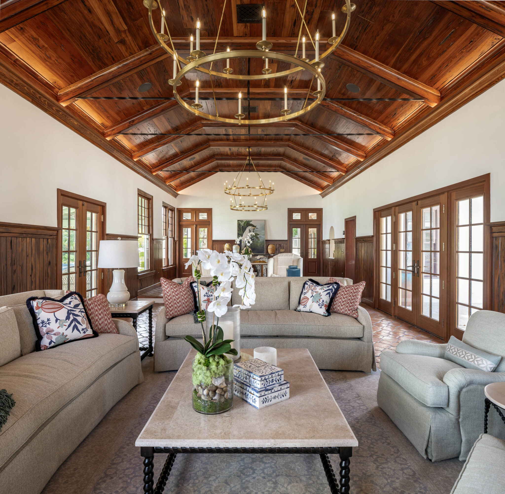 Living room under a vaulted wood ceiling with a ring chandelier