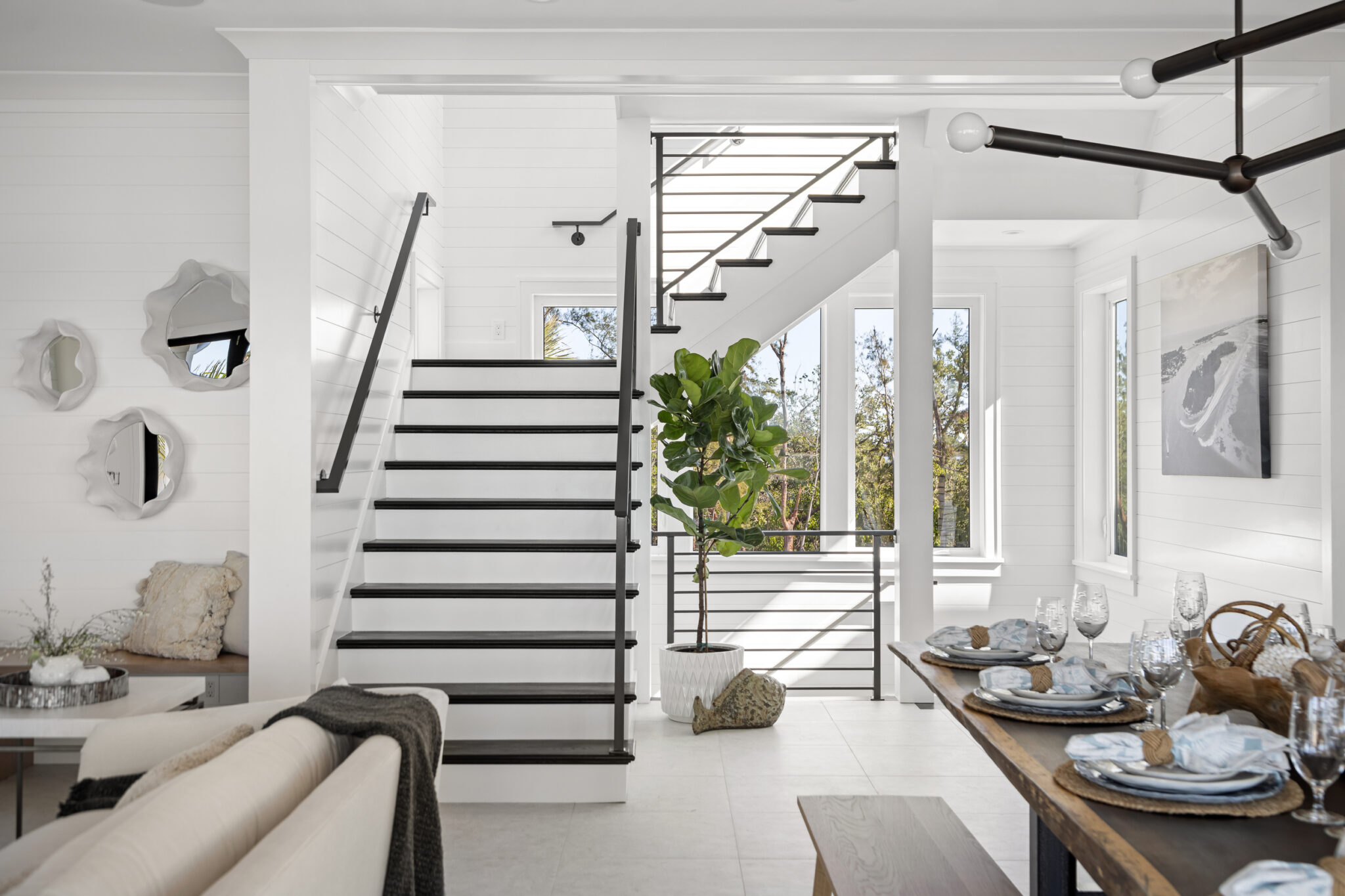 Black steel stair rising beside the dining area