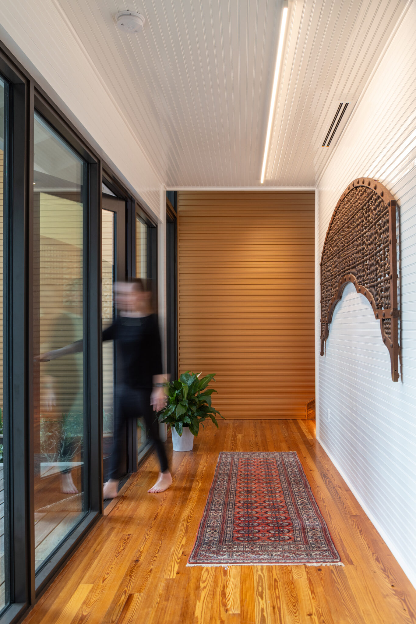 Glass hallway with wood floors connecting old and new