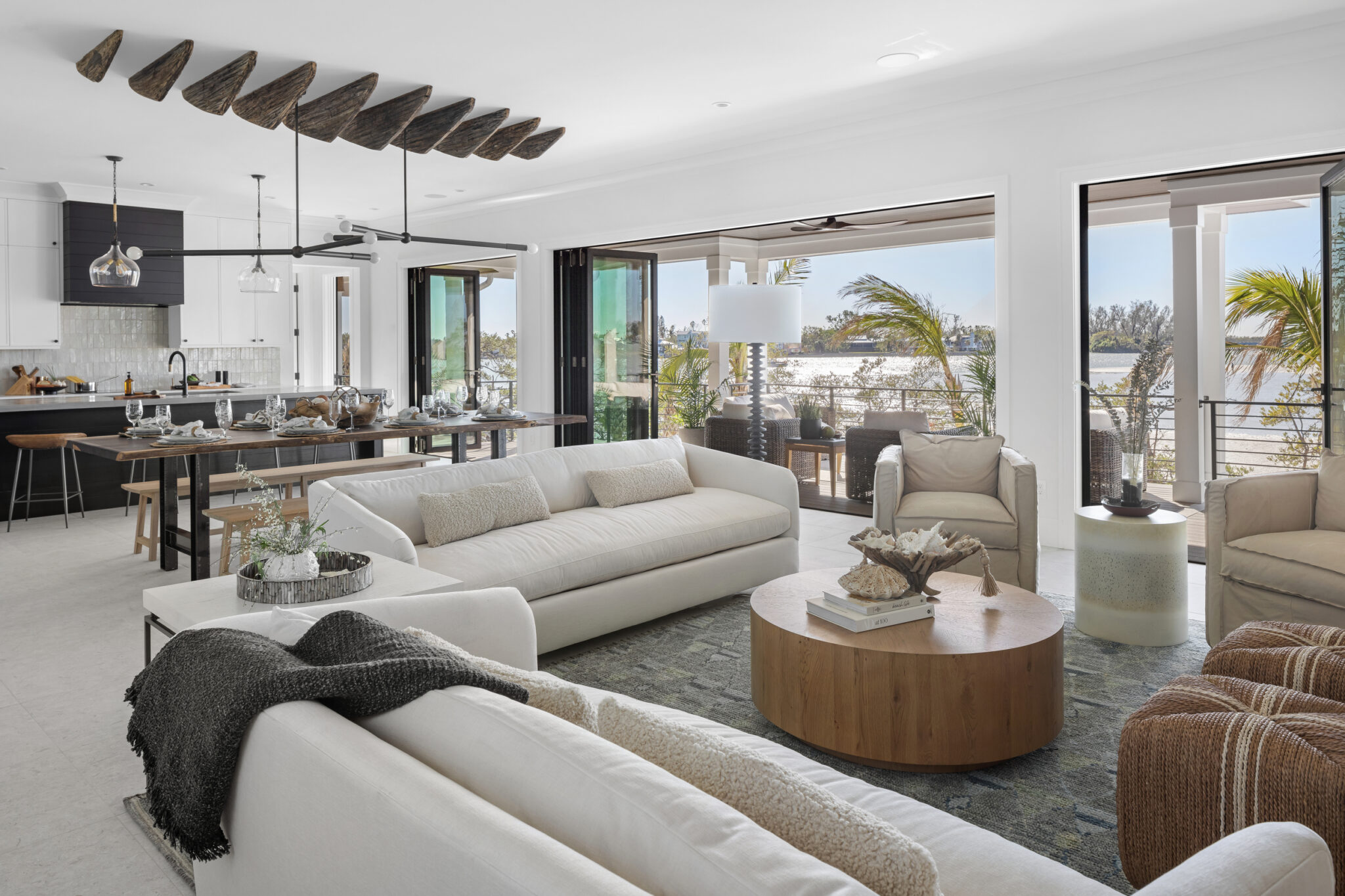 Great room with white sofas and walls of glass to the porch