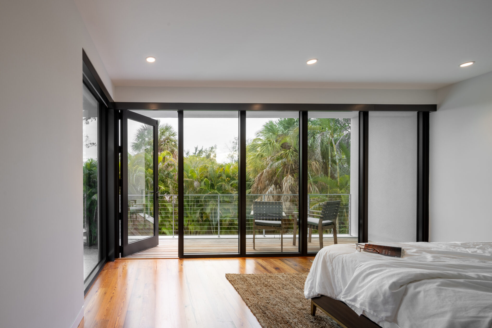 Bedroom with sliding glass doors to the balcony and trees