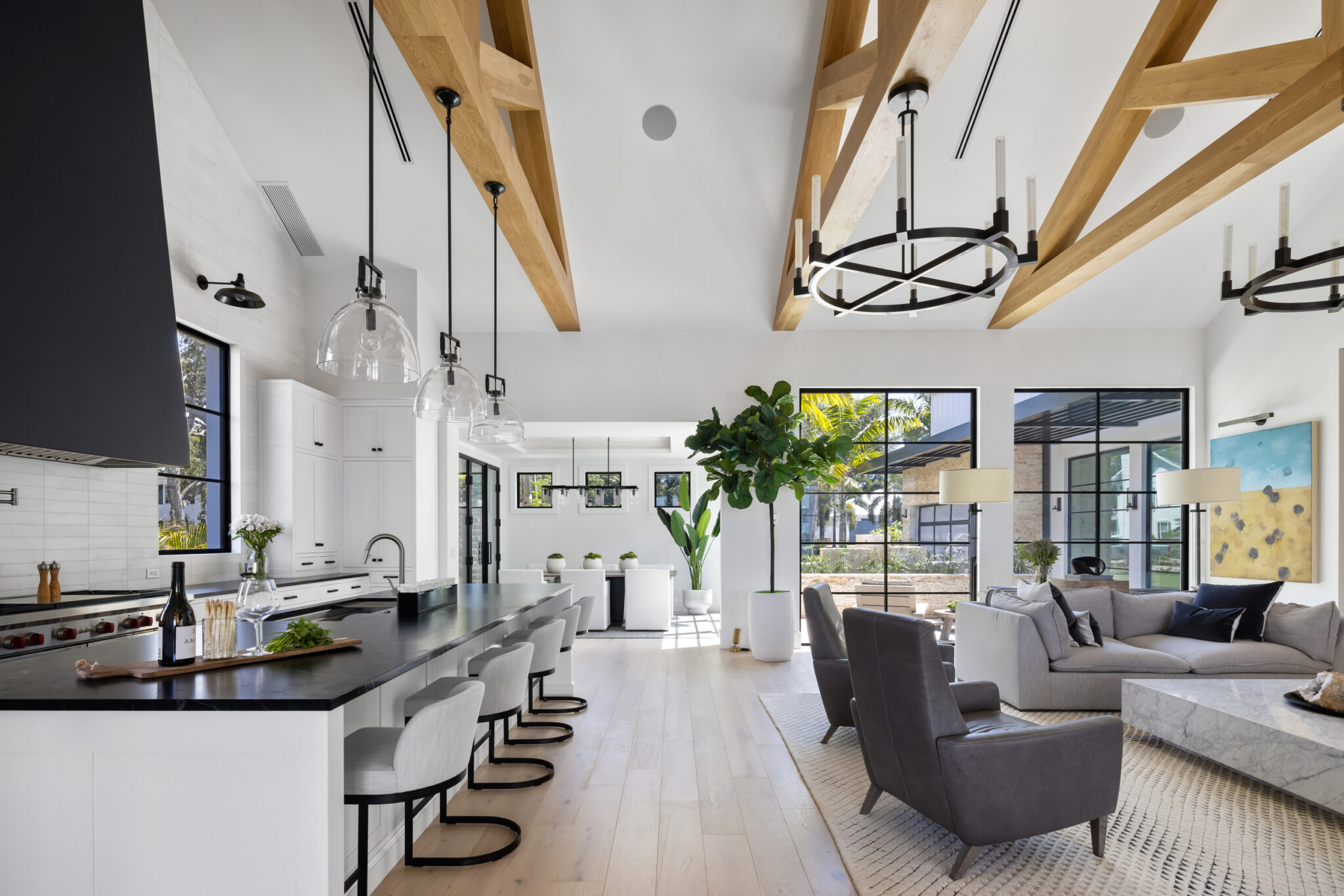 Open kitchen and living room under timber trusses with steel windows