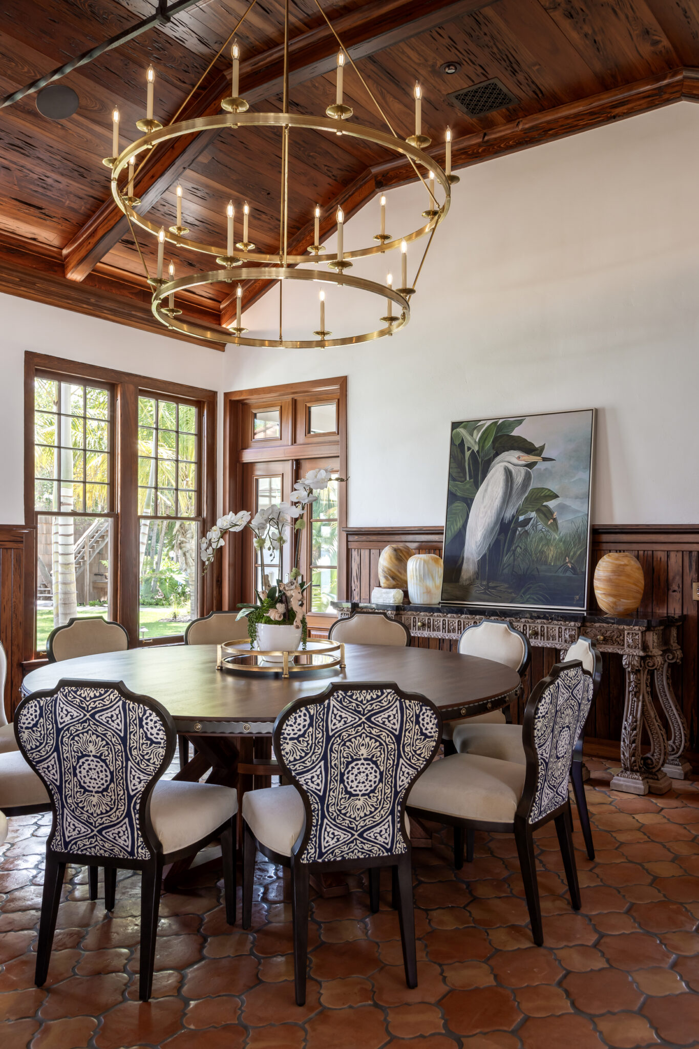 Dining room with a brass chandelier and terracotta tile floor