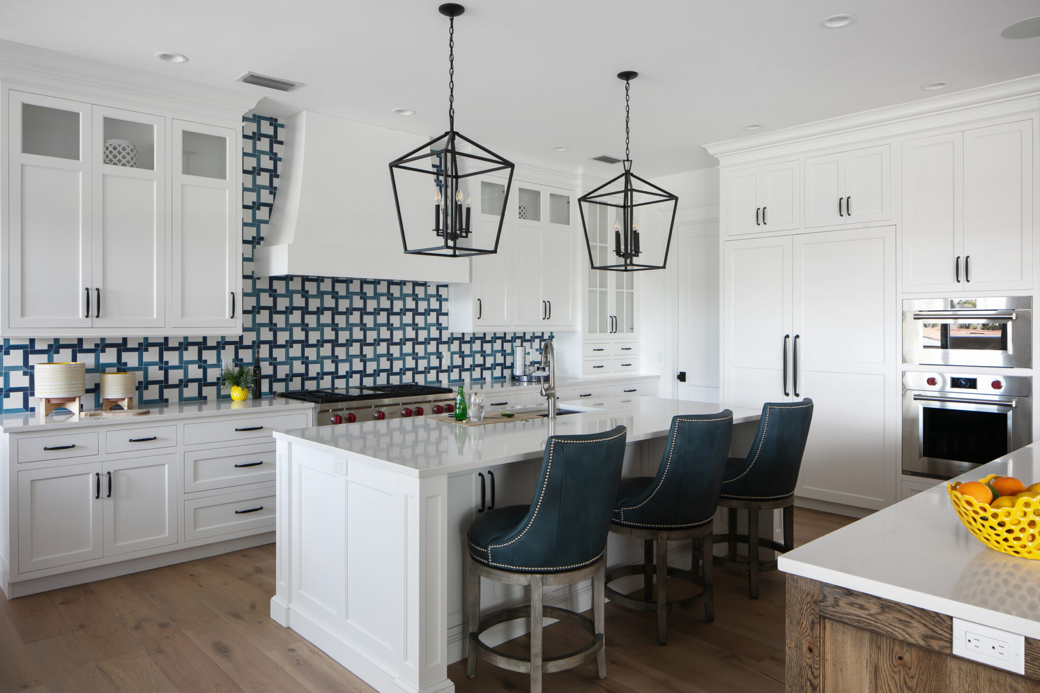 White shaker kitchen with lantern pendants and a patterned backsplash