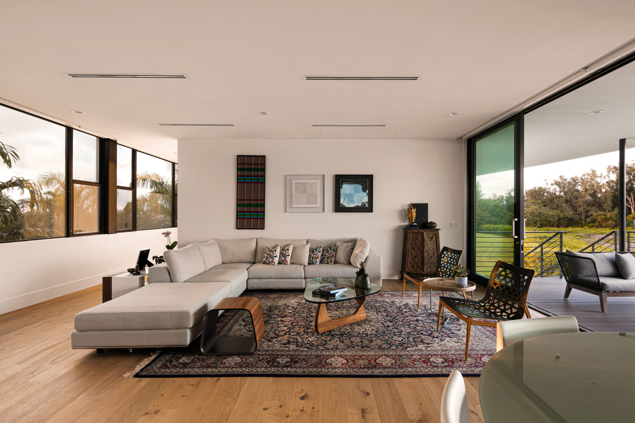 Living room with a sectional and rug, open to the bay through sliding glass
