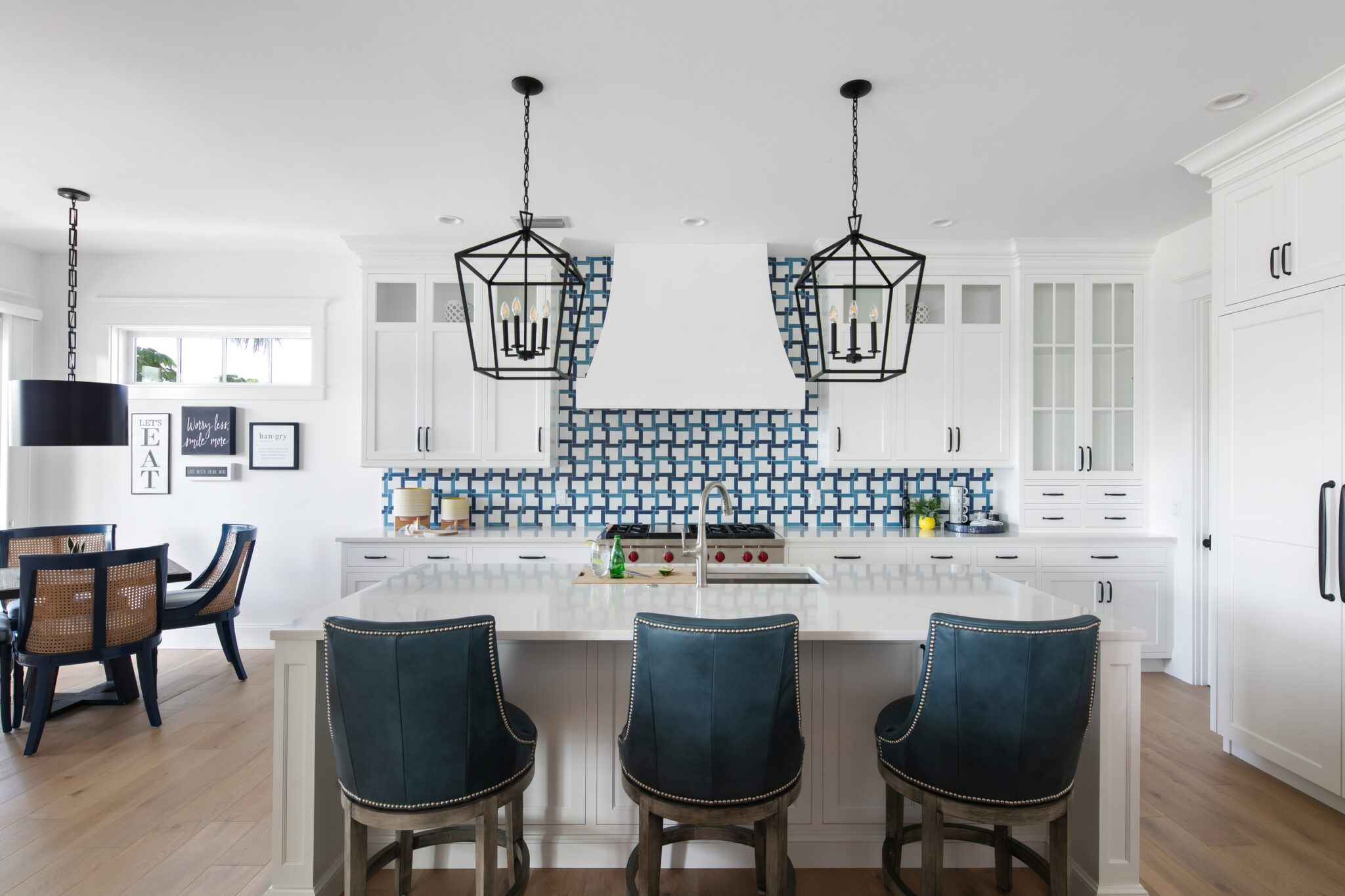 Kitchen with a blue-and-white patterned backsplash and navy stools