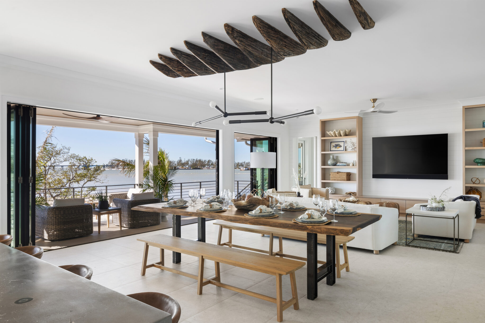 Living and dining area under reclaimed-wood beams, open to the porch
