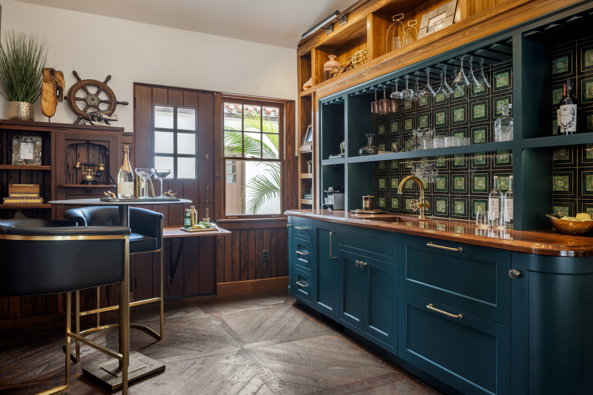 Navy bar with glass-front cabinets and brass stools