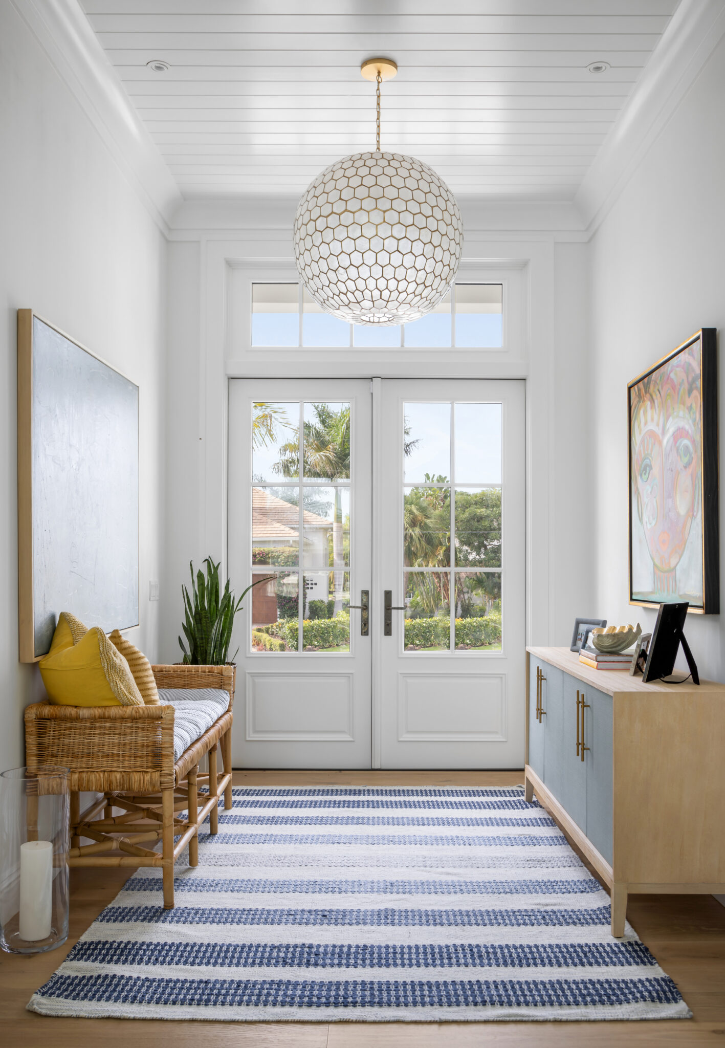 Entry hall with a beaded chandelier and striped runner
