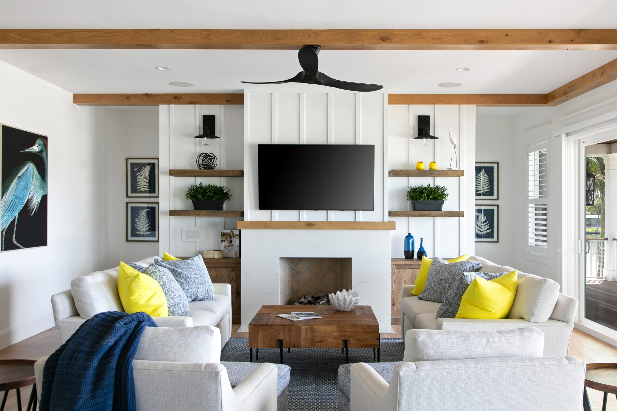 Living room with a fireplace, floating shelves and yellow pillows