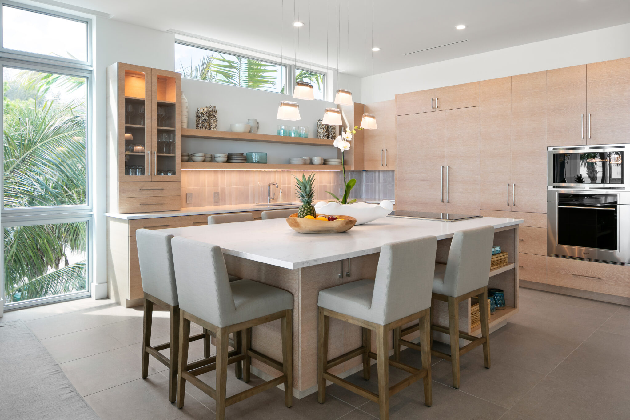 Kitchen with light wood cabinets, open shelves and an island table