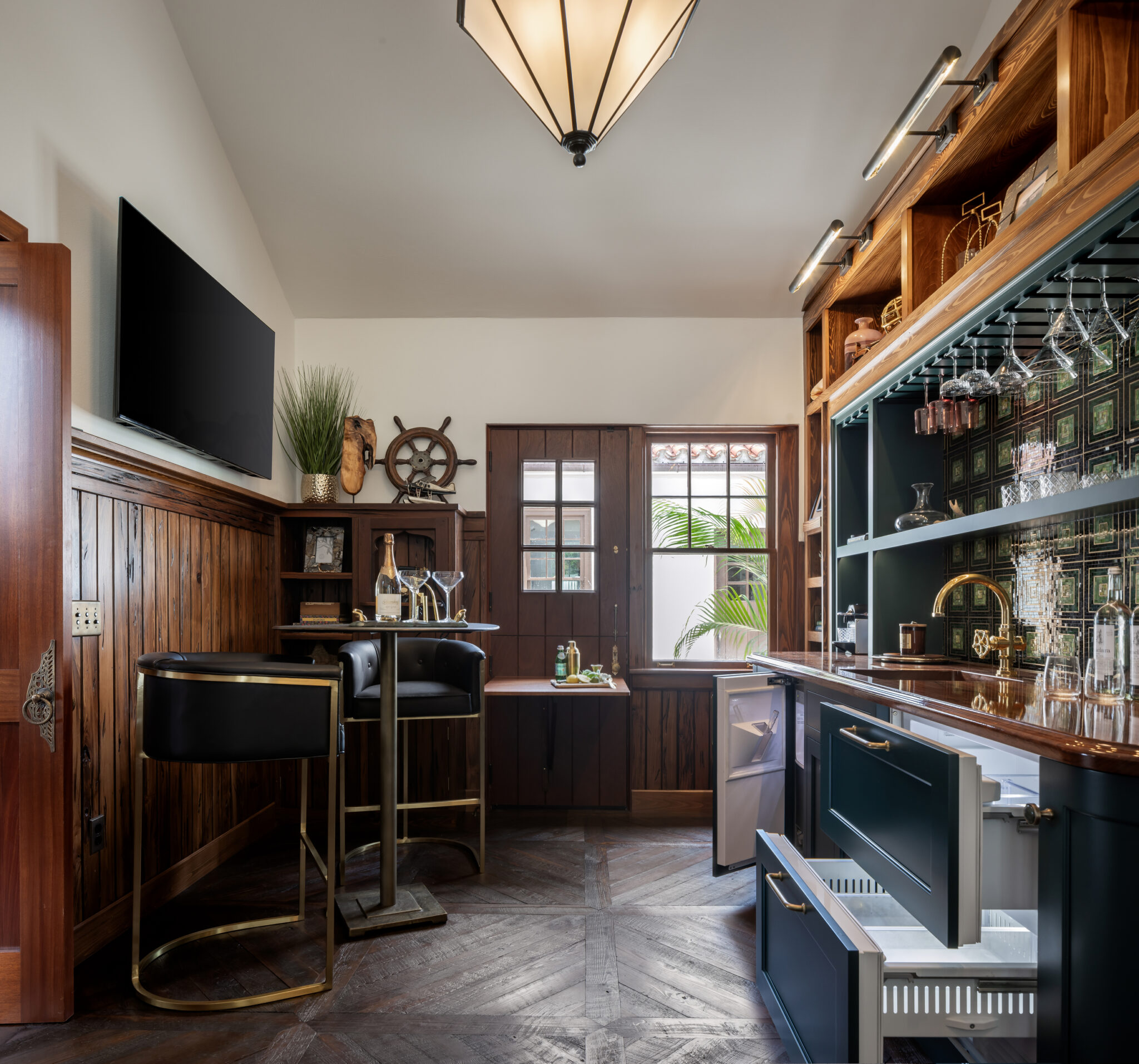 Navy bar and wood-paneled lounge with a pendant light