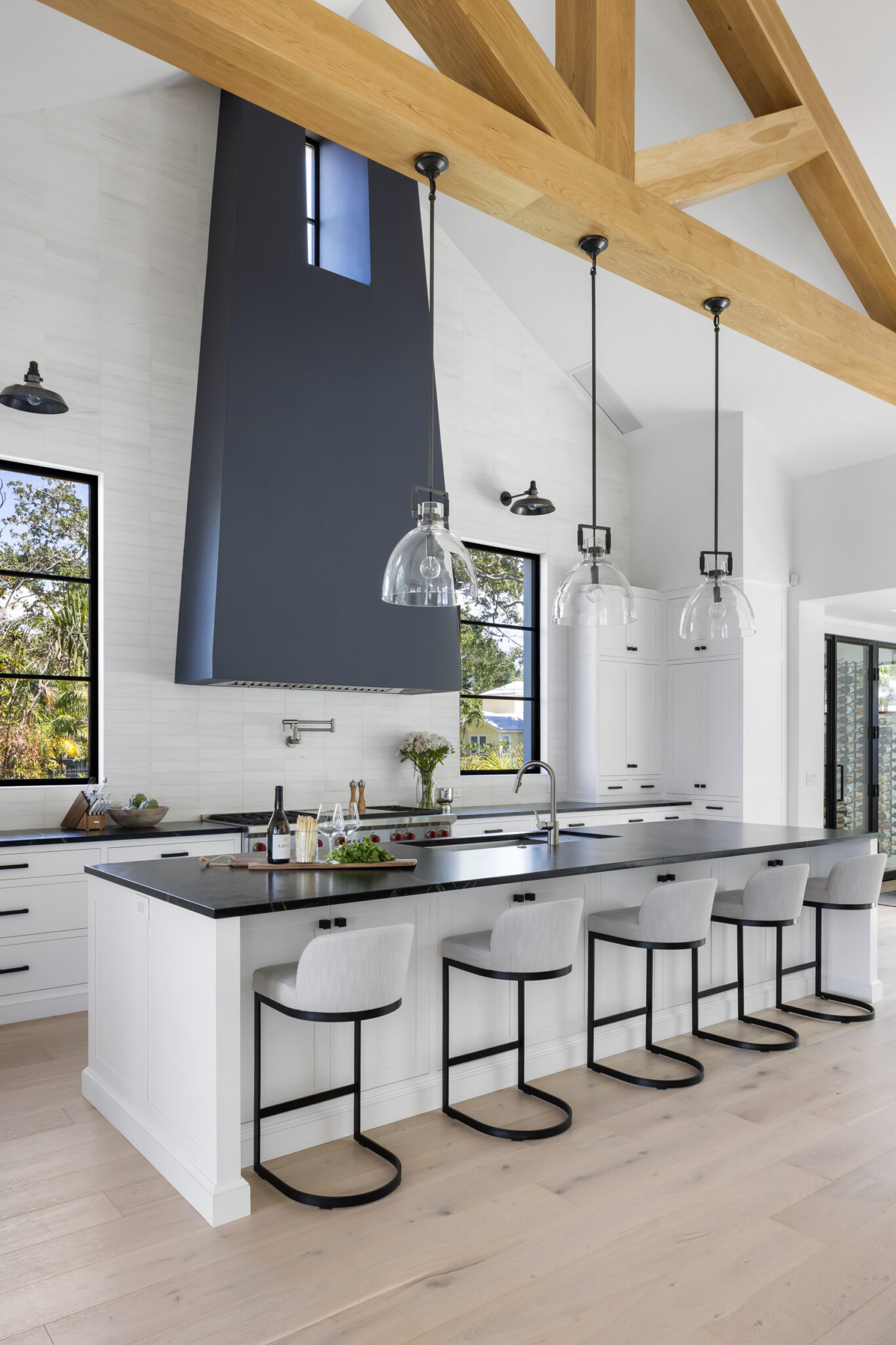 Kitchen island seating under a tall black range hood