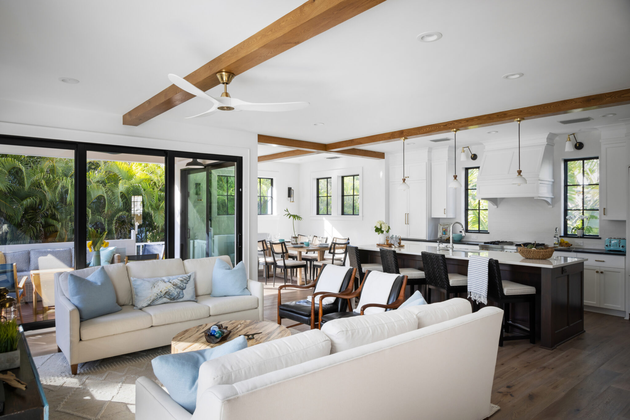 Open living, dining and kitchen under exposed wood beams