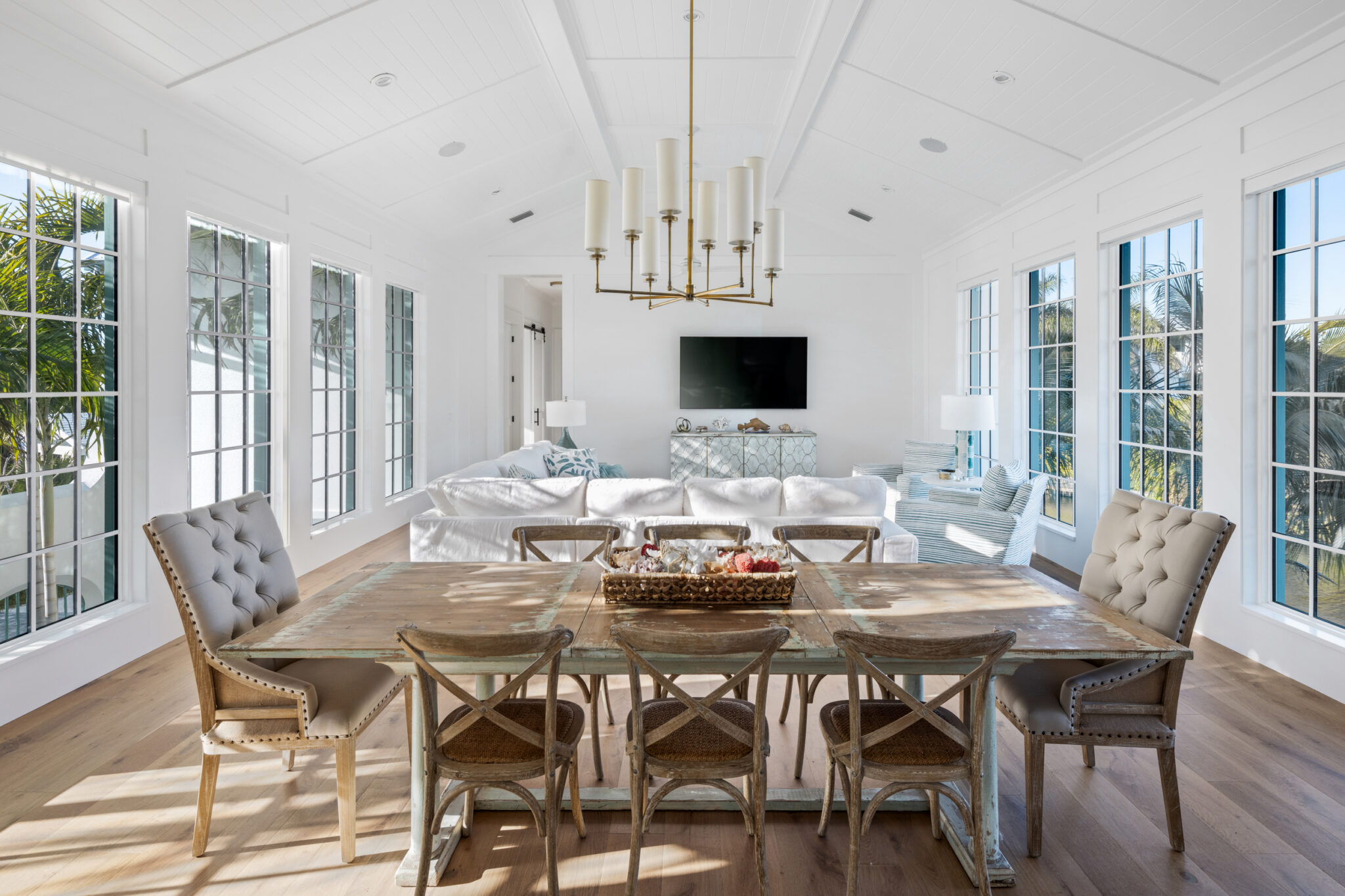 Dining room with a long table and brass chandelier under a vaulted ceiling