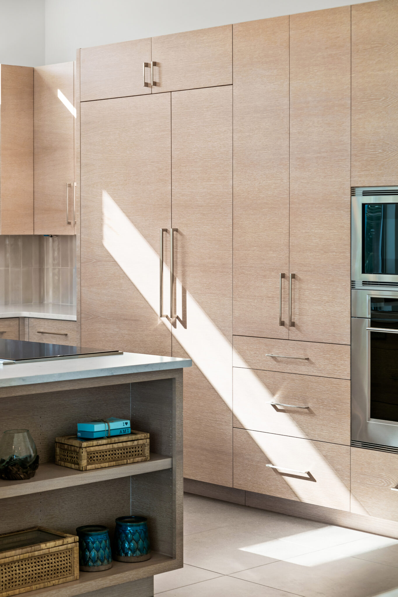 Tall light wood pantry cabinets beside the kitchen
