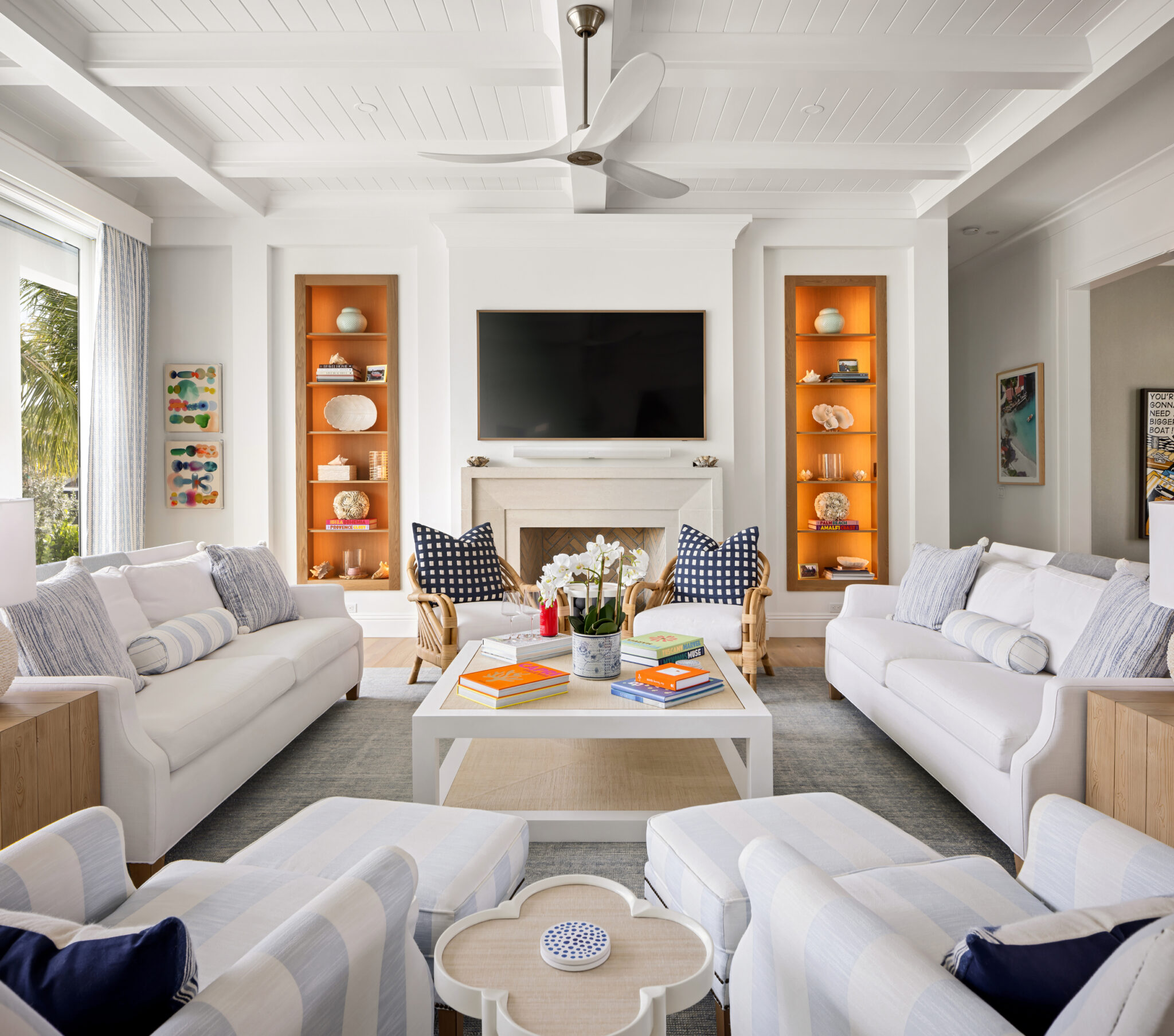 Living room with a fireplace flanked by lit orange shelves