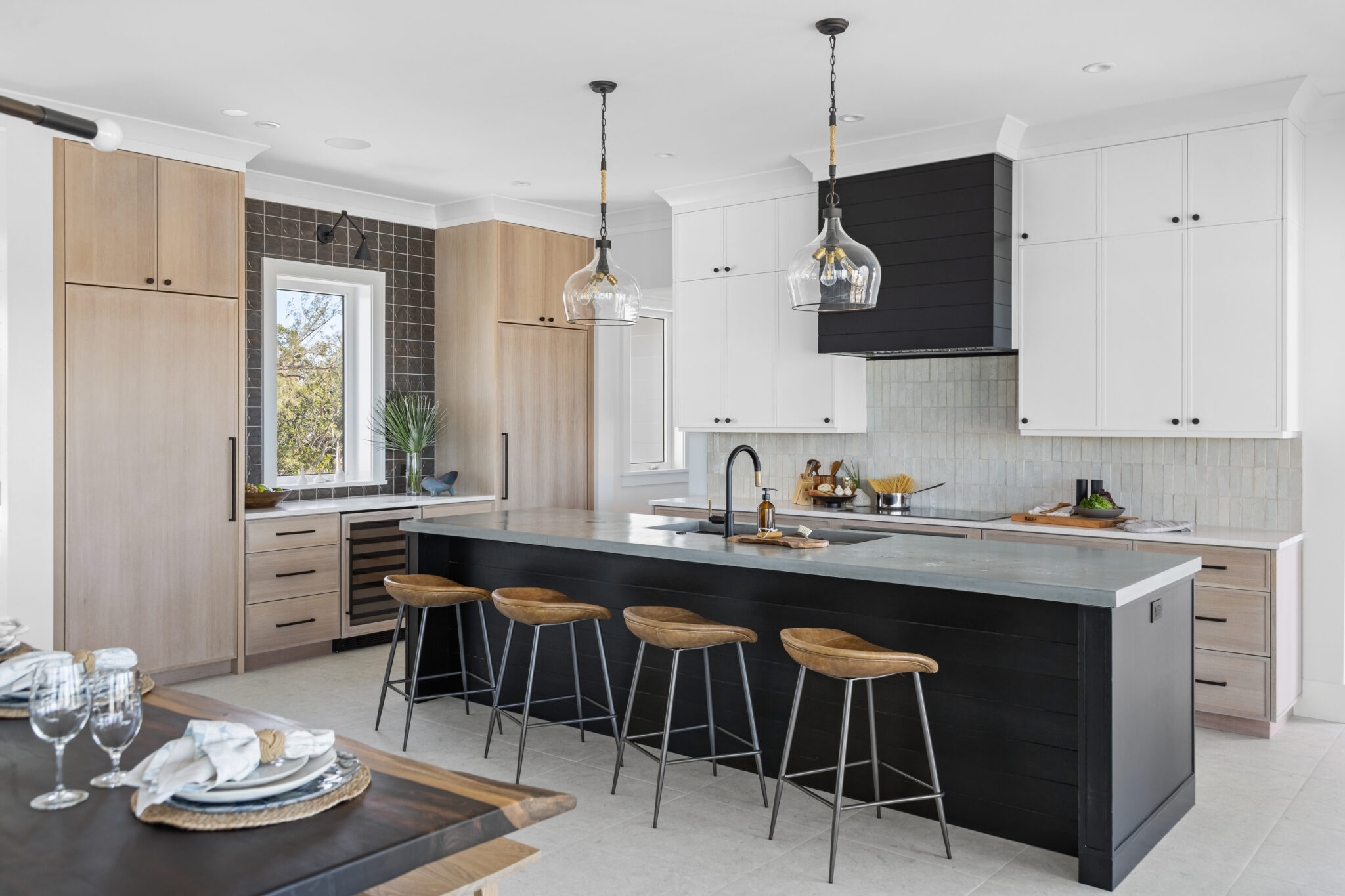 Kitchen with a black island, oak cabinets and stools