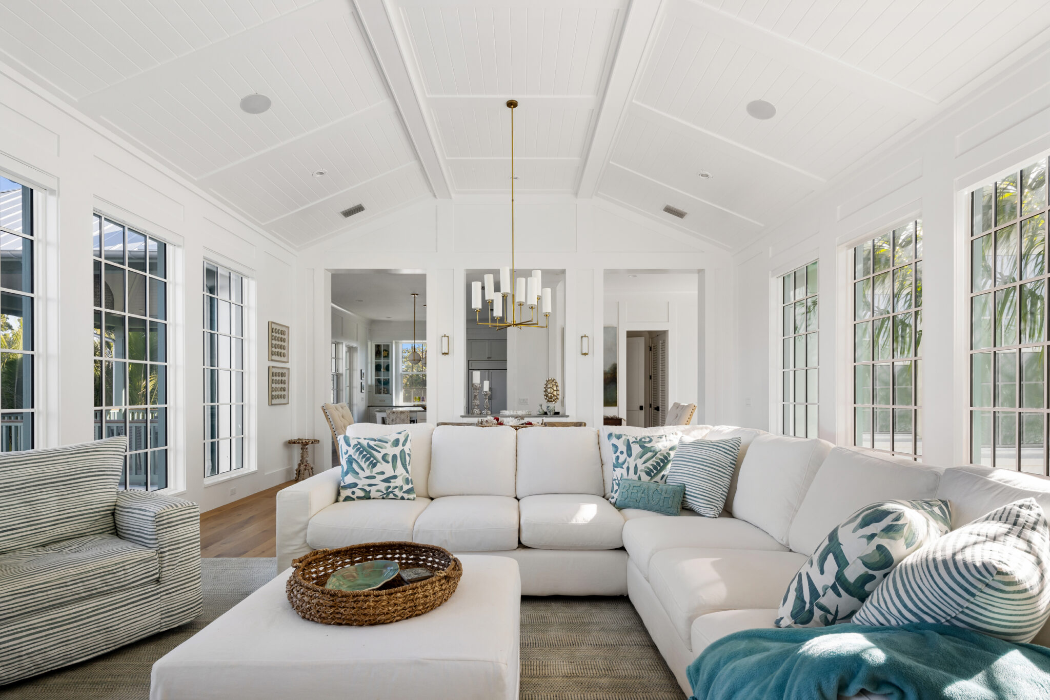 Living room with a white sectional and walls of multi-pane windows