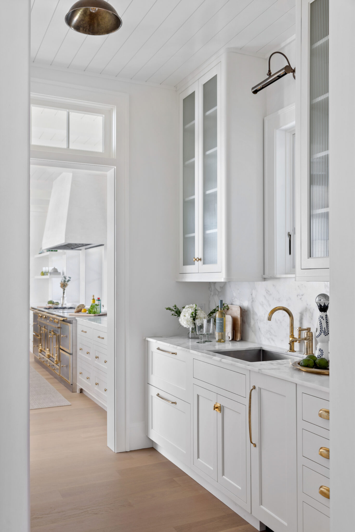 Butler's pantry with white cabinetry and brass hardware