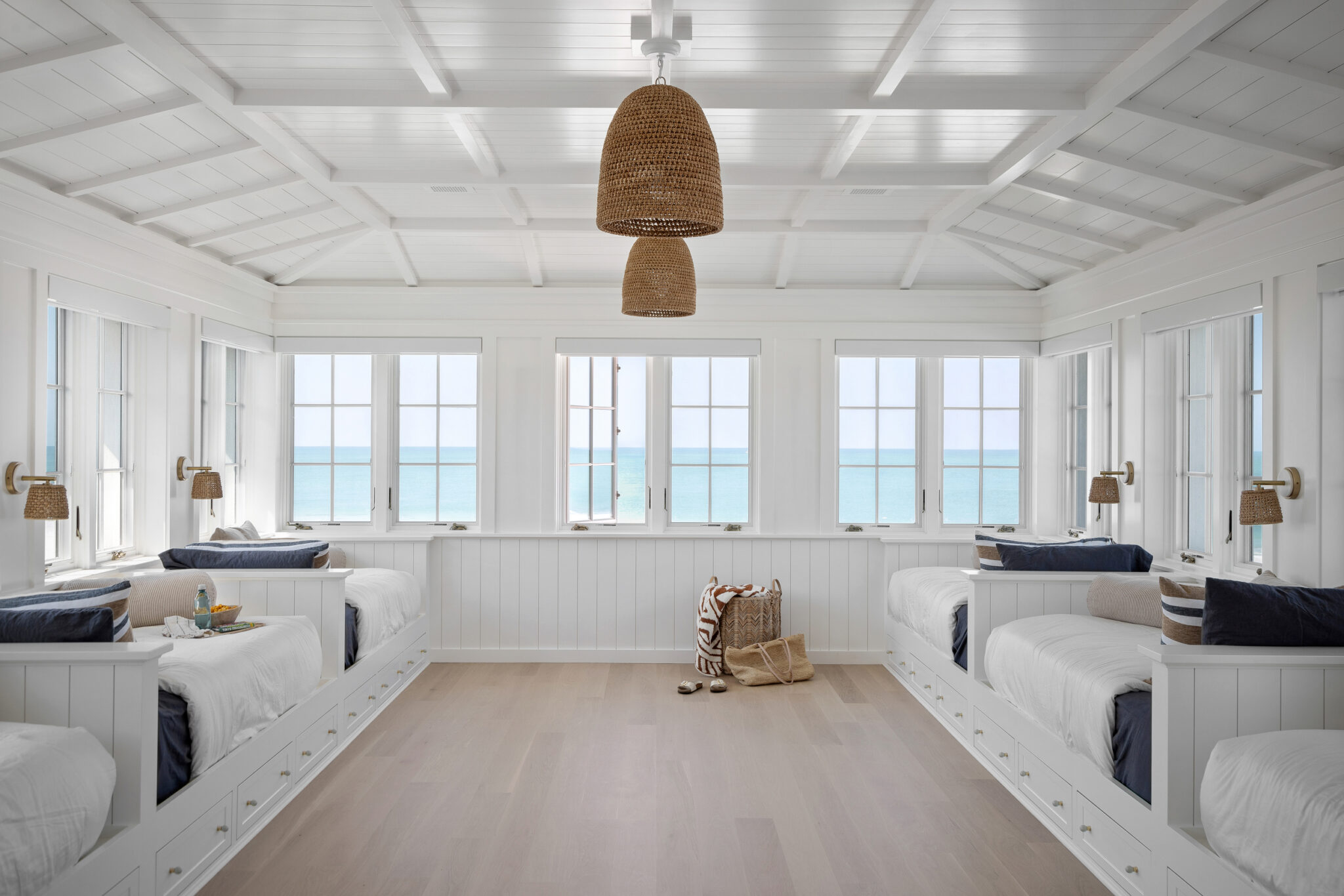 Bunk room with built-in daybeds under a wall of windows