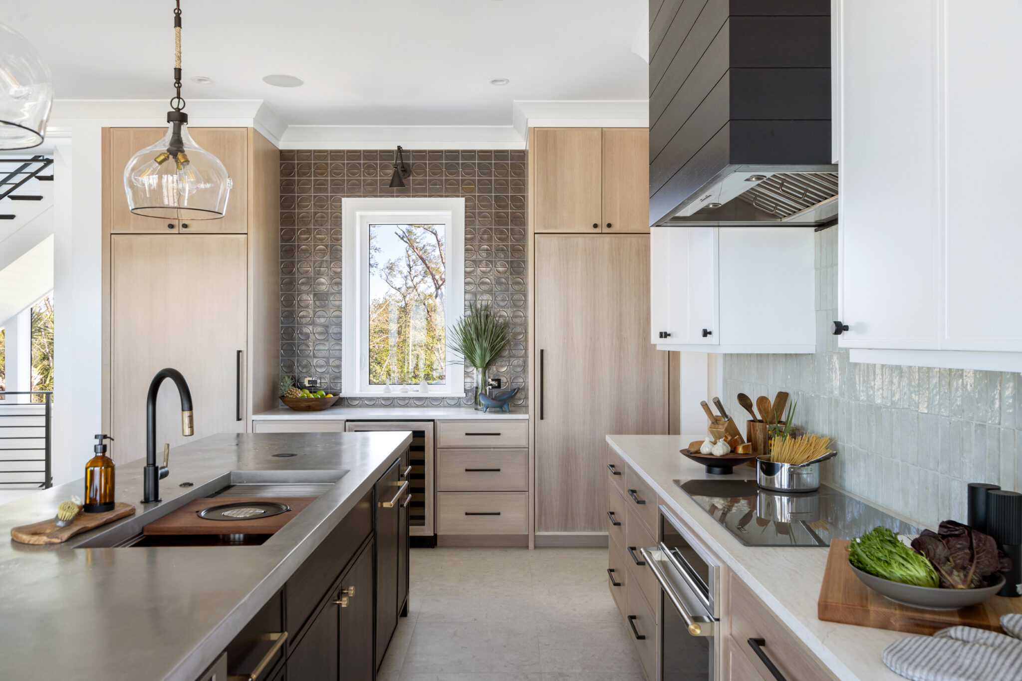 Kitchen with white oak cabinetry, black island and black range hood