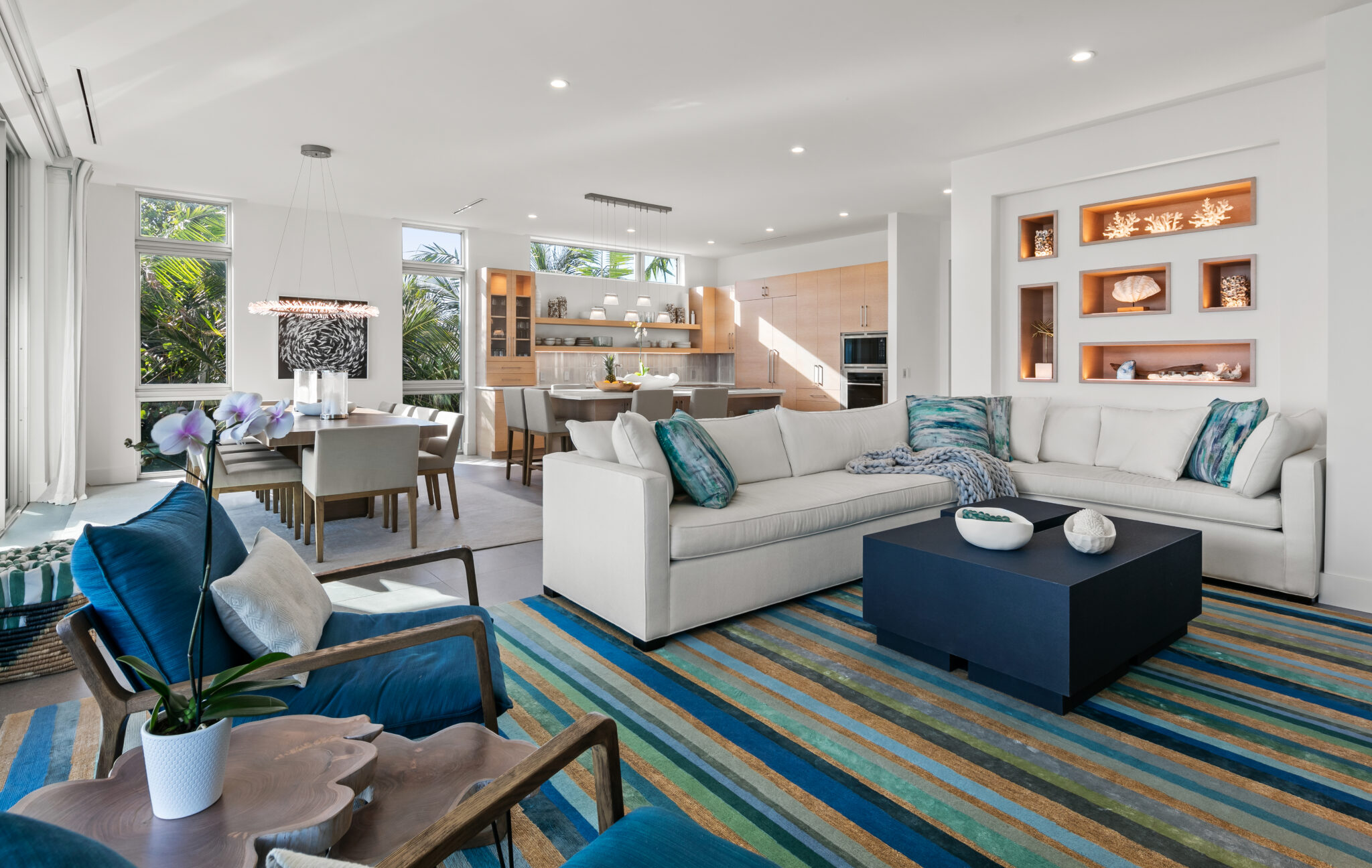 Living room with a blue striped rug and teal accent chairs