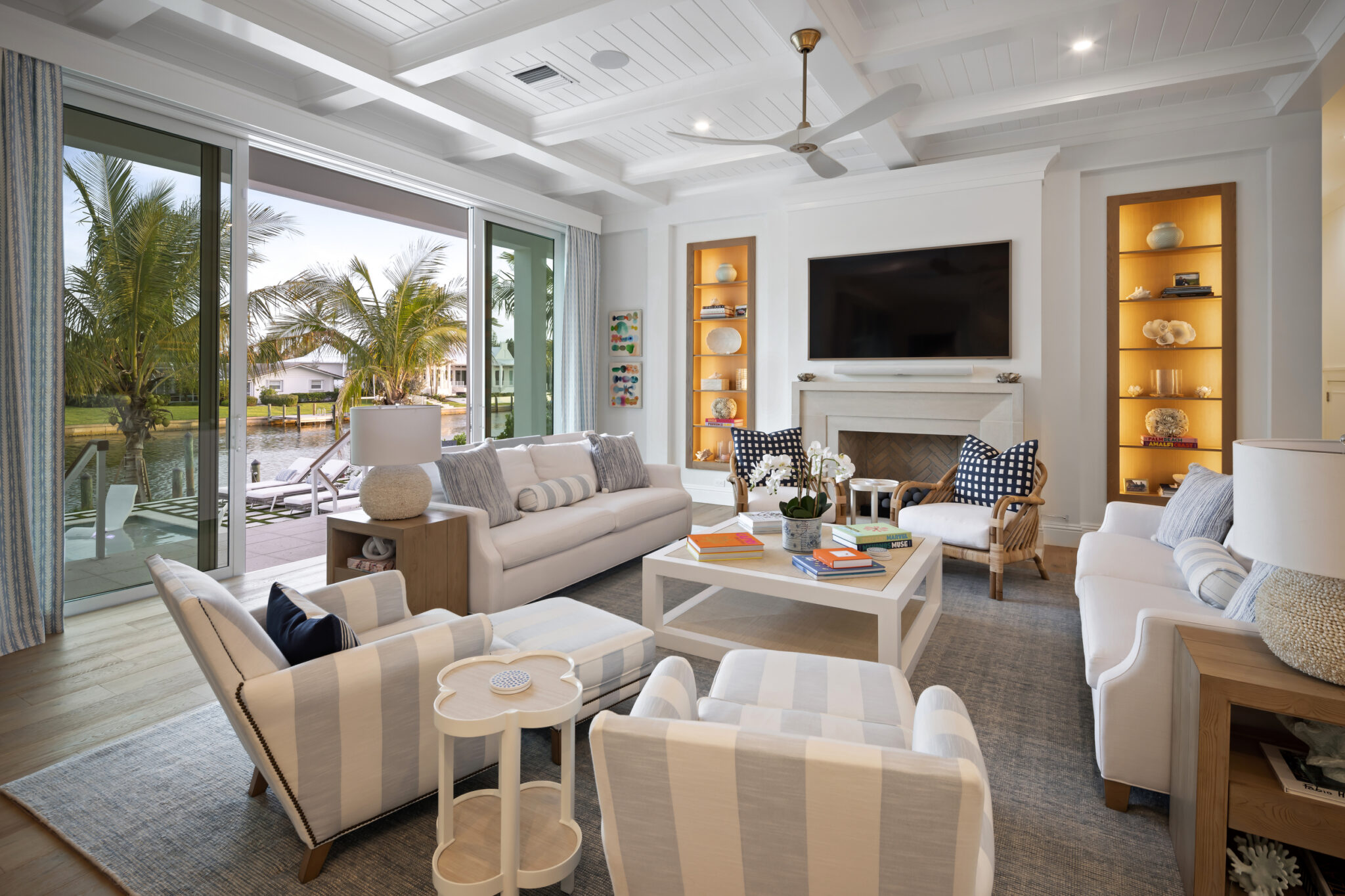Living room with a fireplace, built-in shelves and doors to the pool