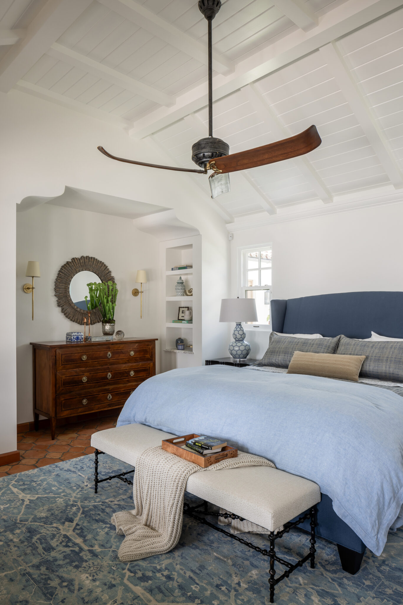 Guest bedroom with a navy headboard and bench