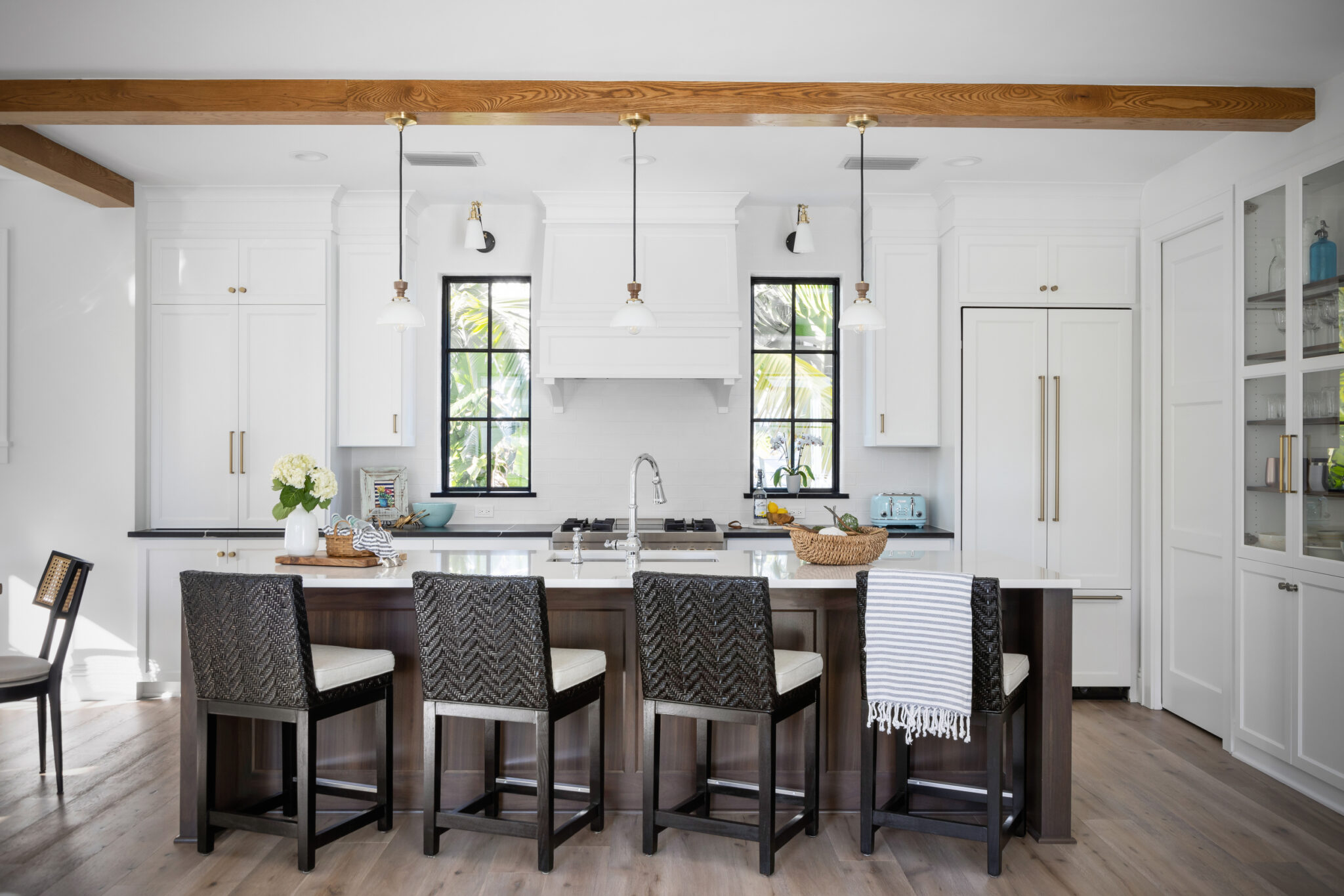 Kitchen island with seating under wood beams and pendants