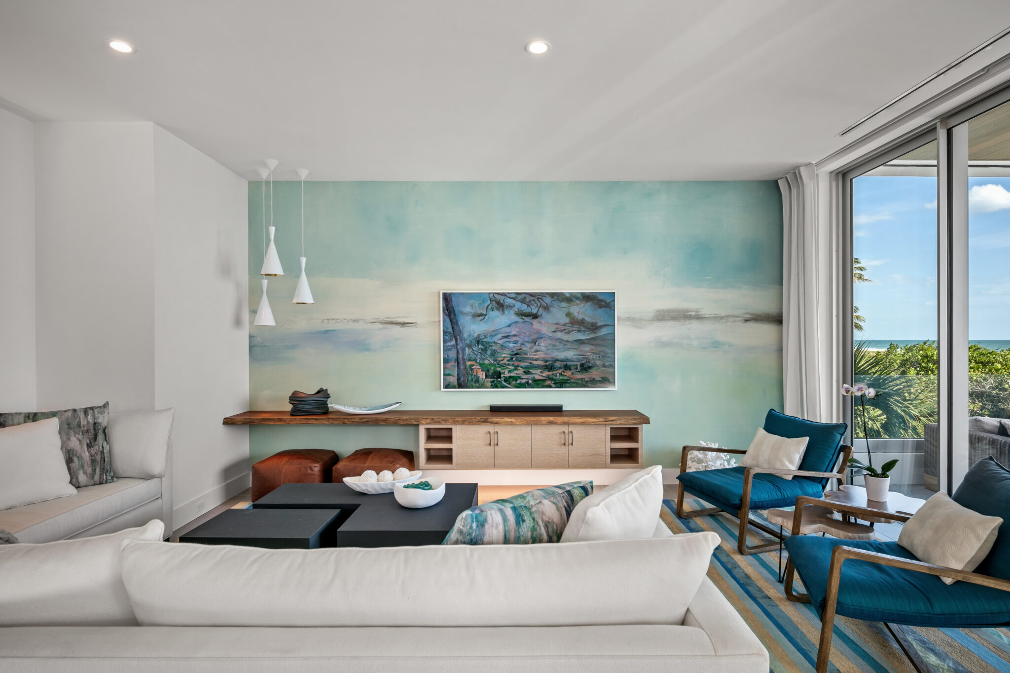 Sitting room with a mural wall and teal chairs