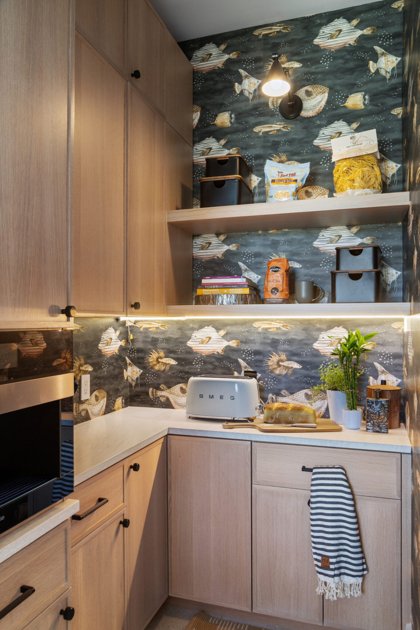 Pantry with oak cabinets and fish-print wallpaper