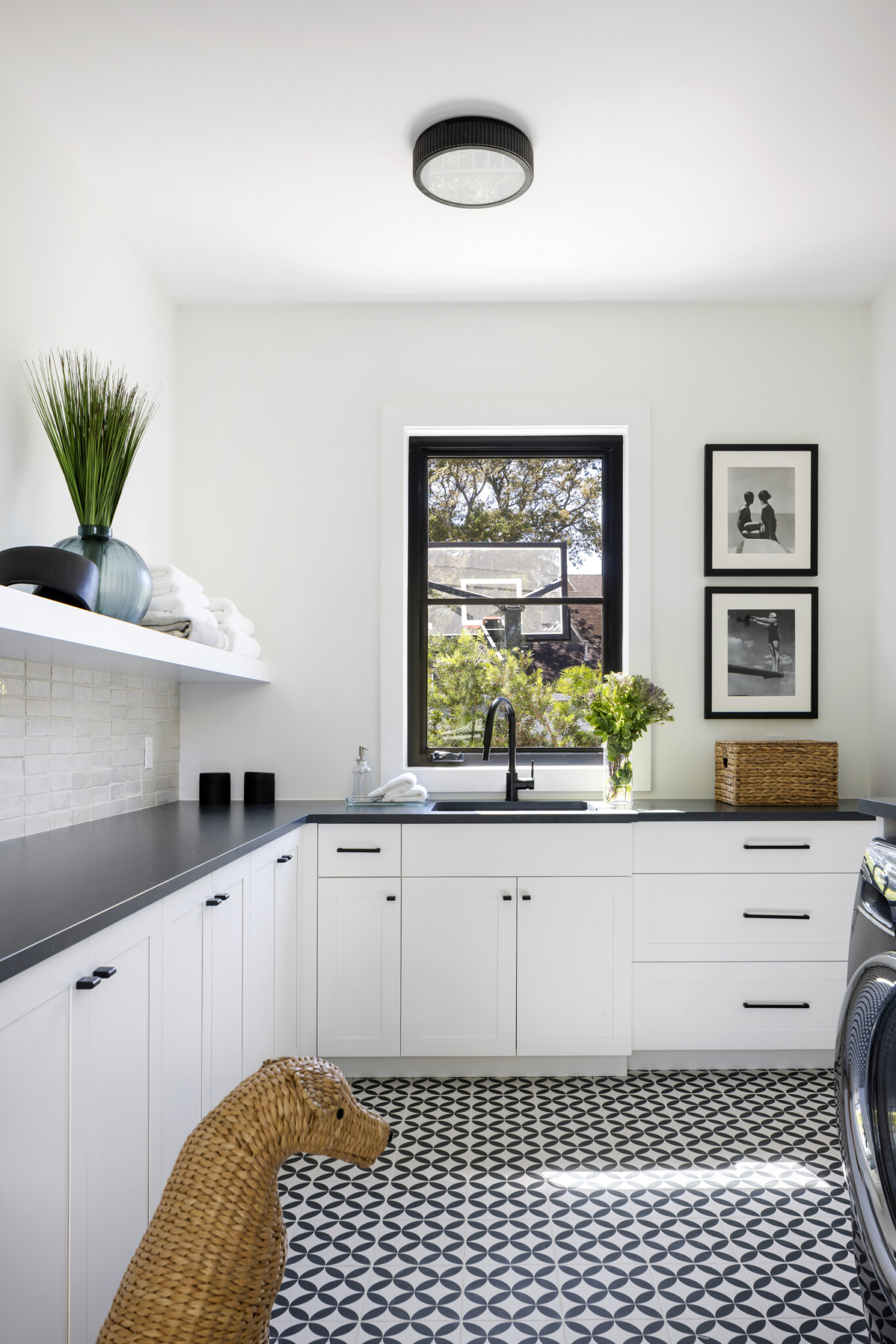 Laundry room with black counters and patterned tile floor
