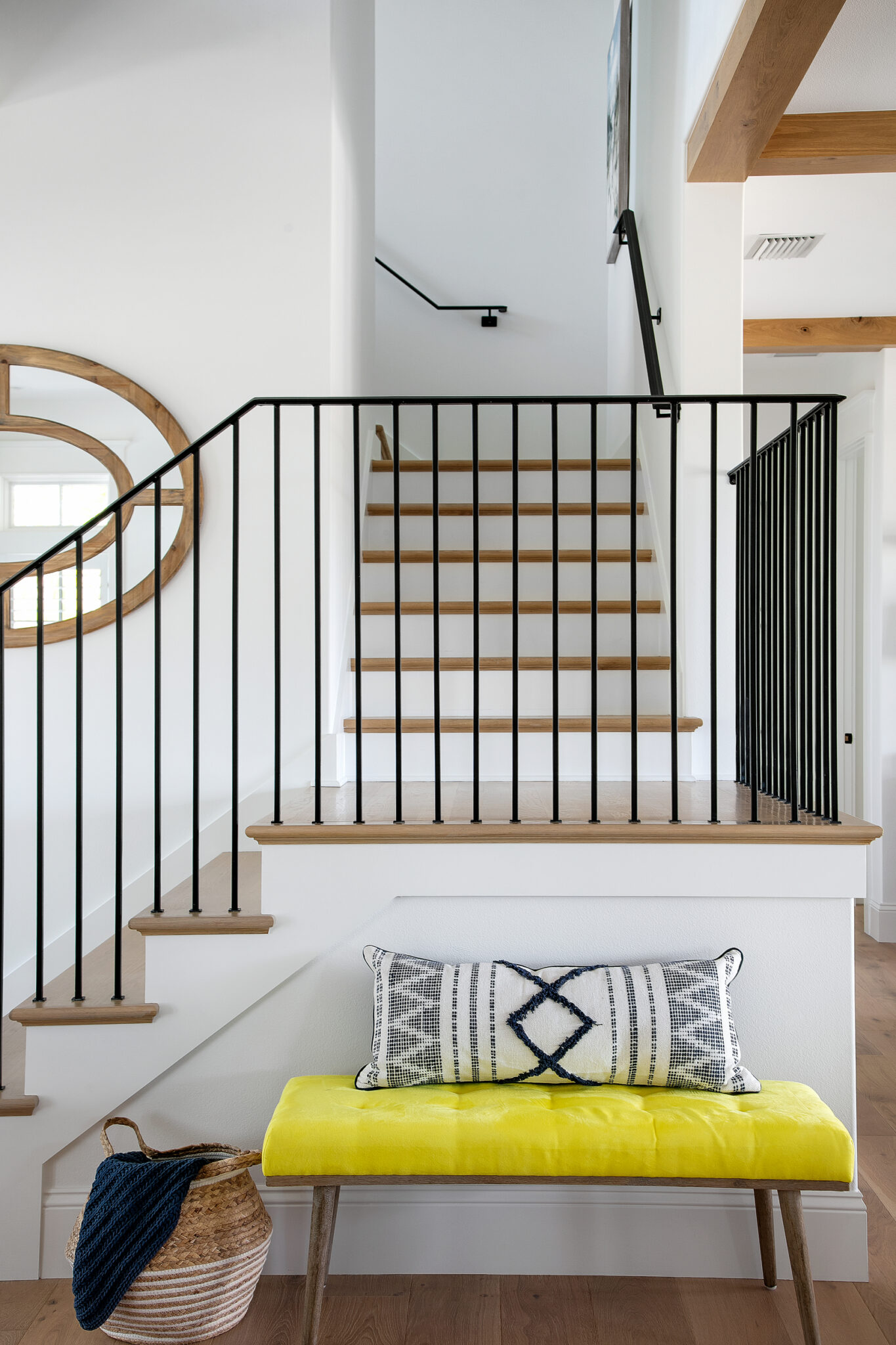 Stair landing with a yellow bench and black railing