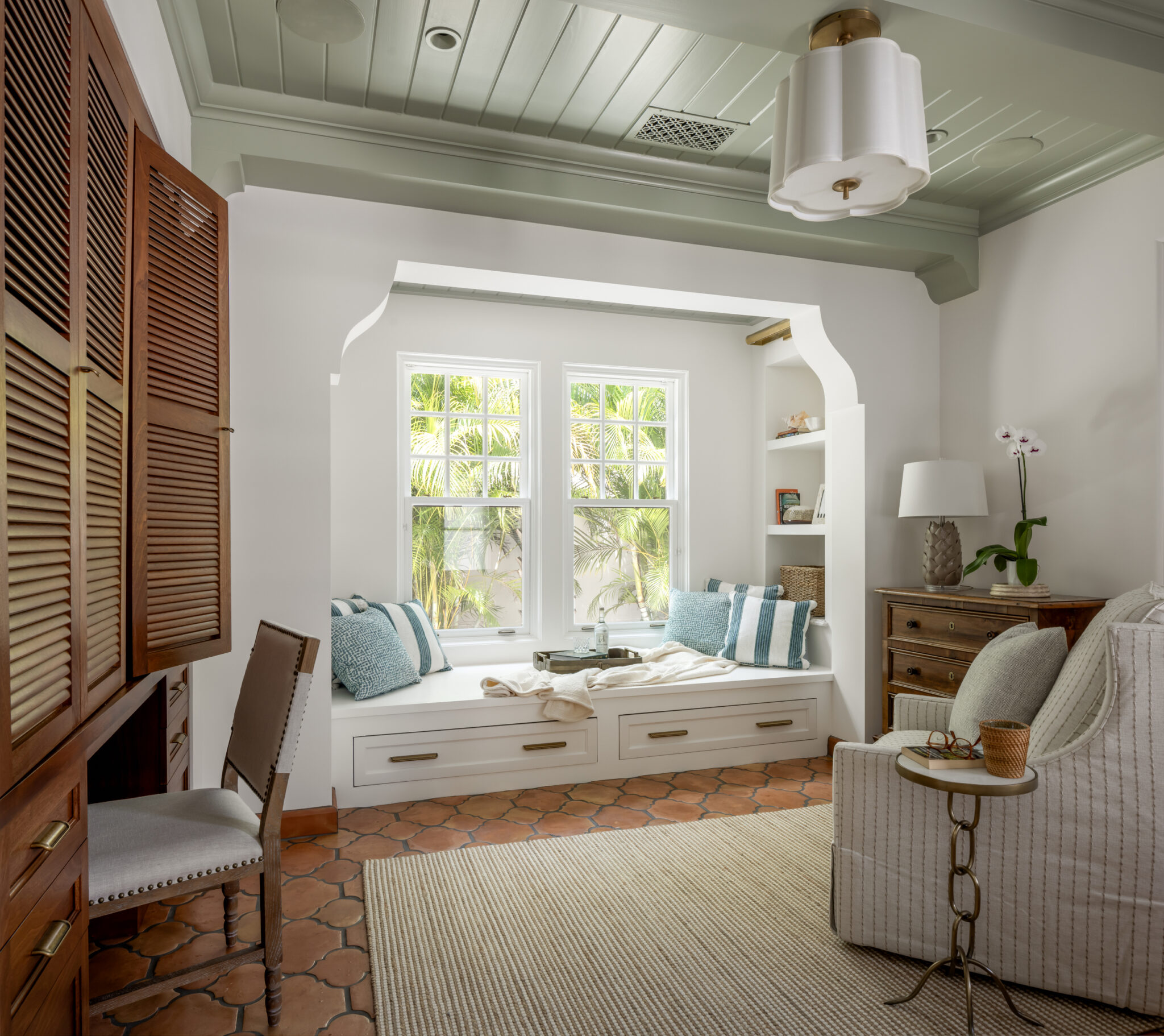 Window seat nook with wood shutters and a painted ceiling