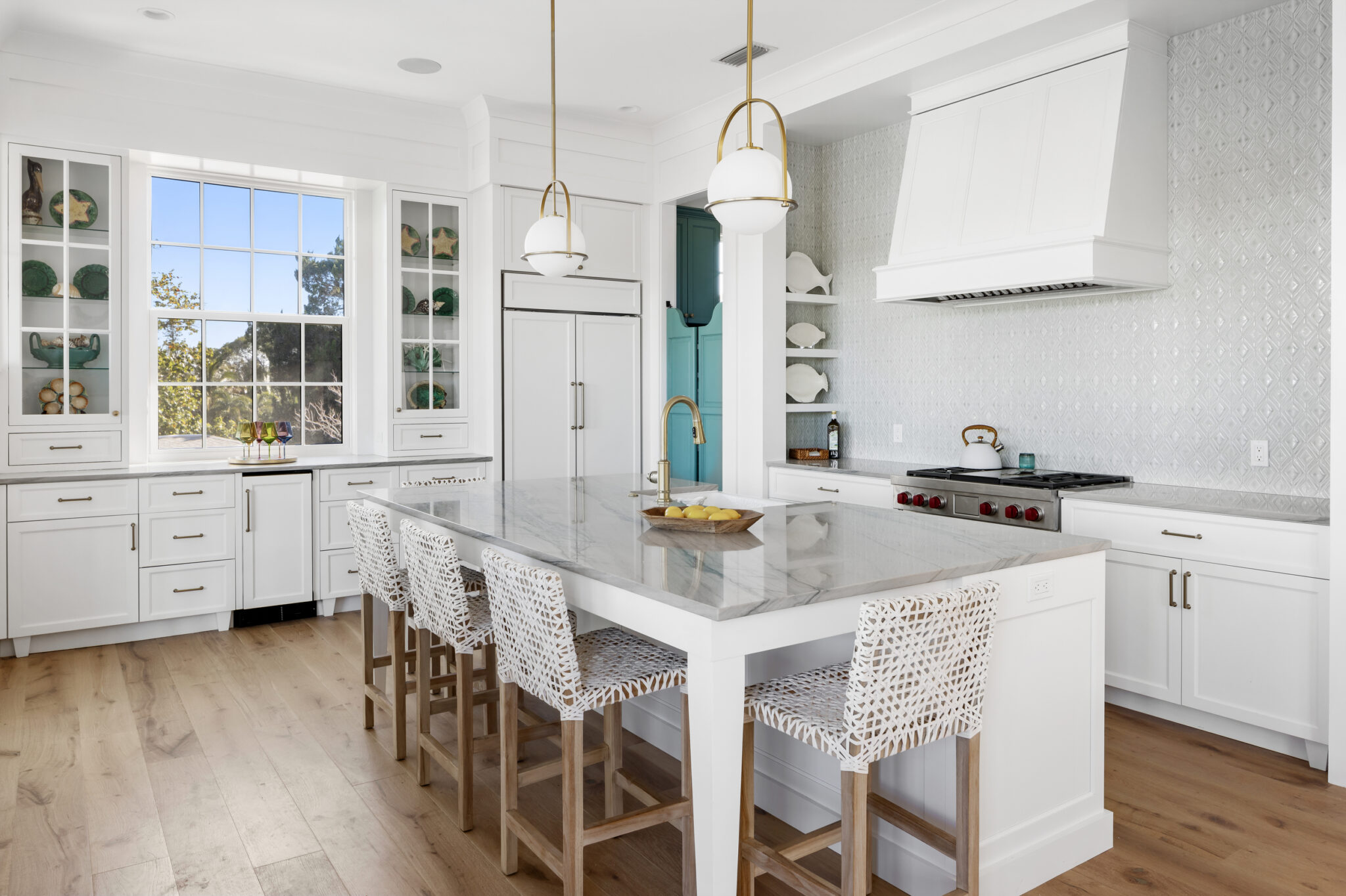 White kitchen with a marble island and patterned stools