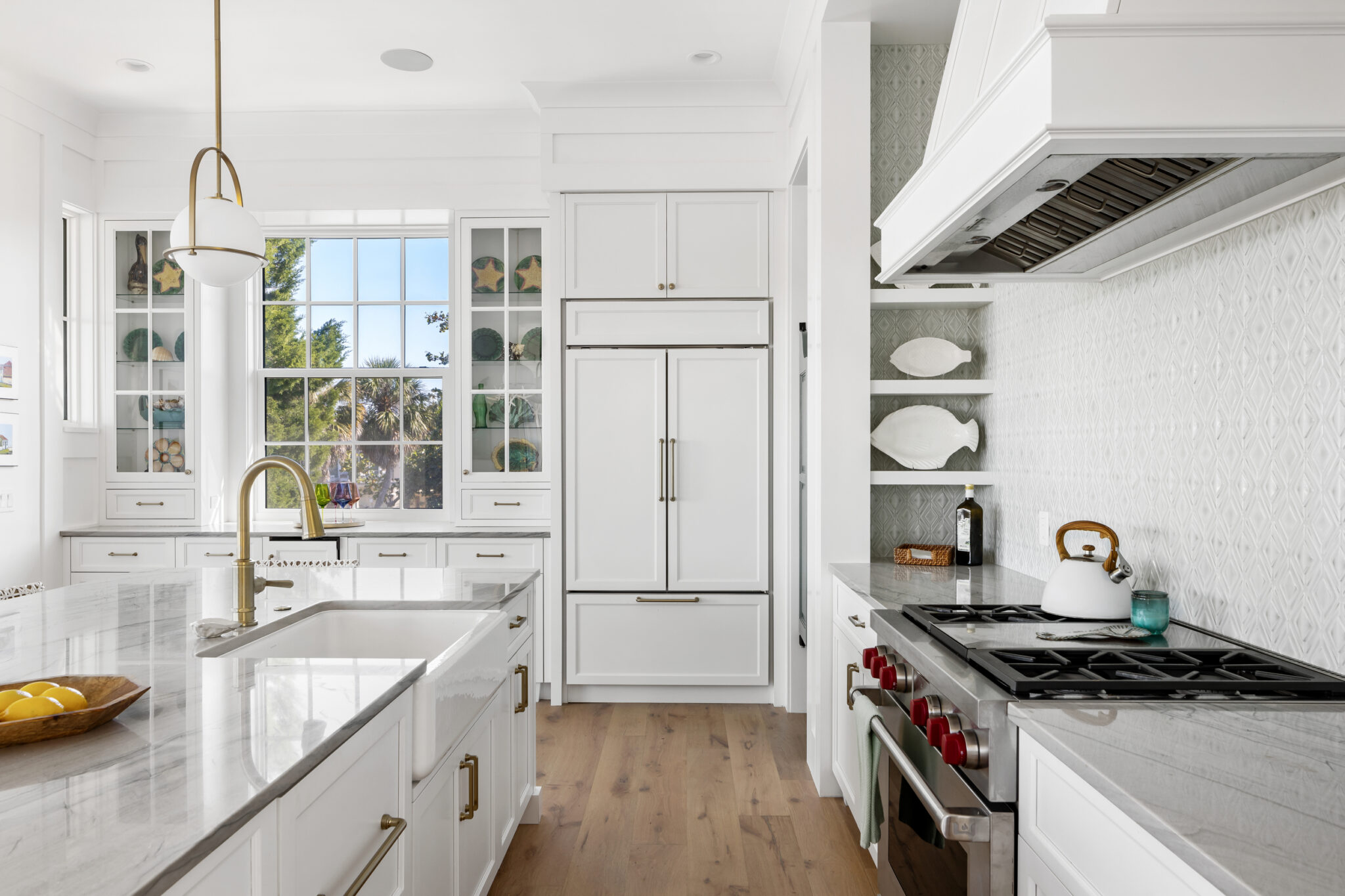 Kitchen with a white range hood, farmhouse sink and marble counters