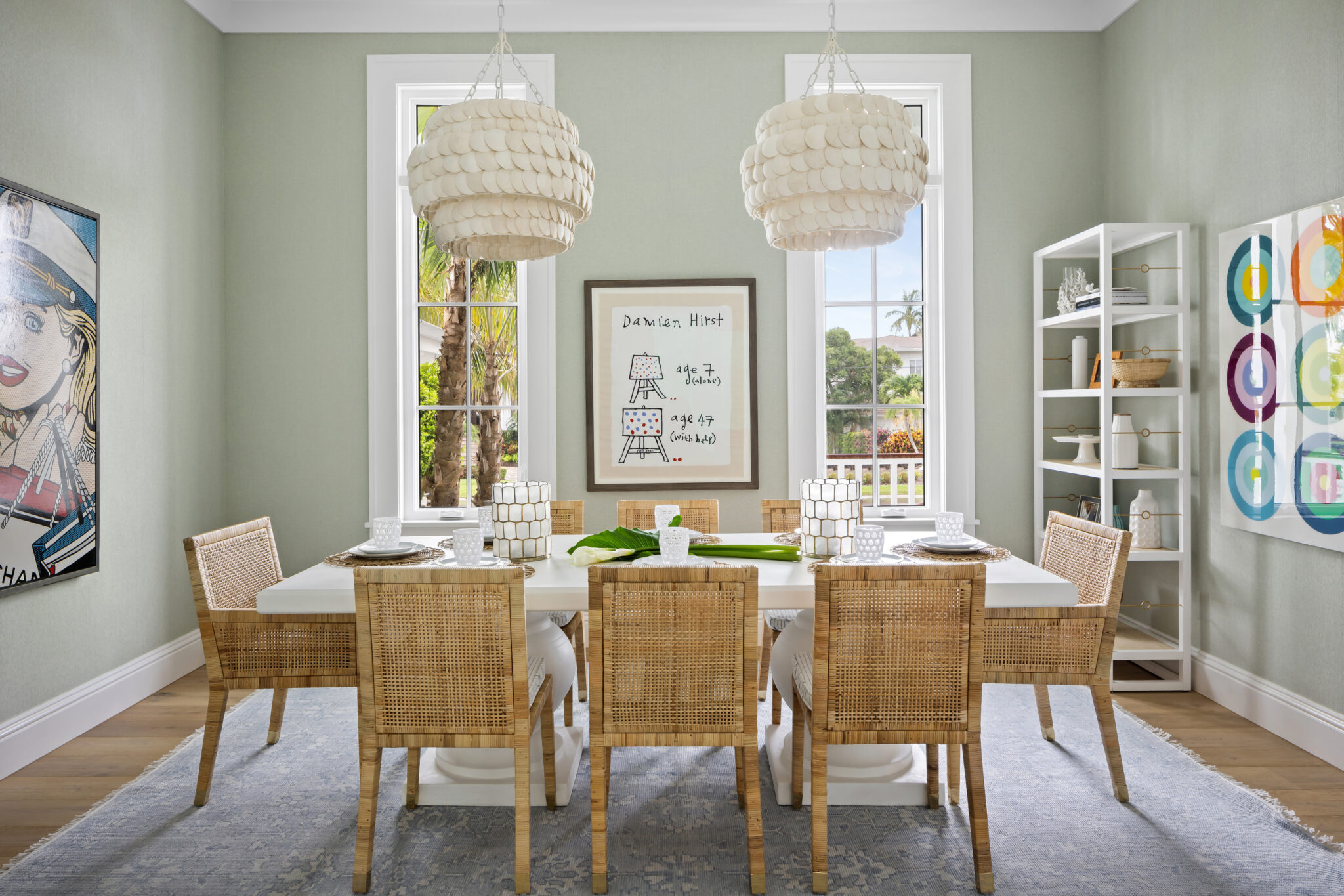 Dining room with sage walls, woven chairs and pendant lights