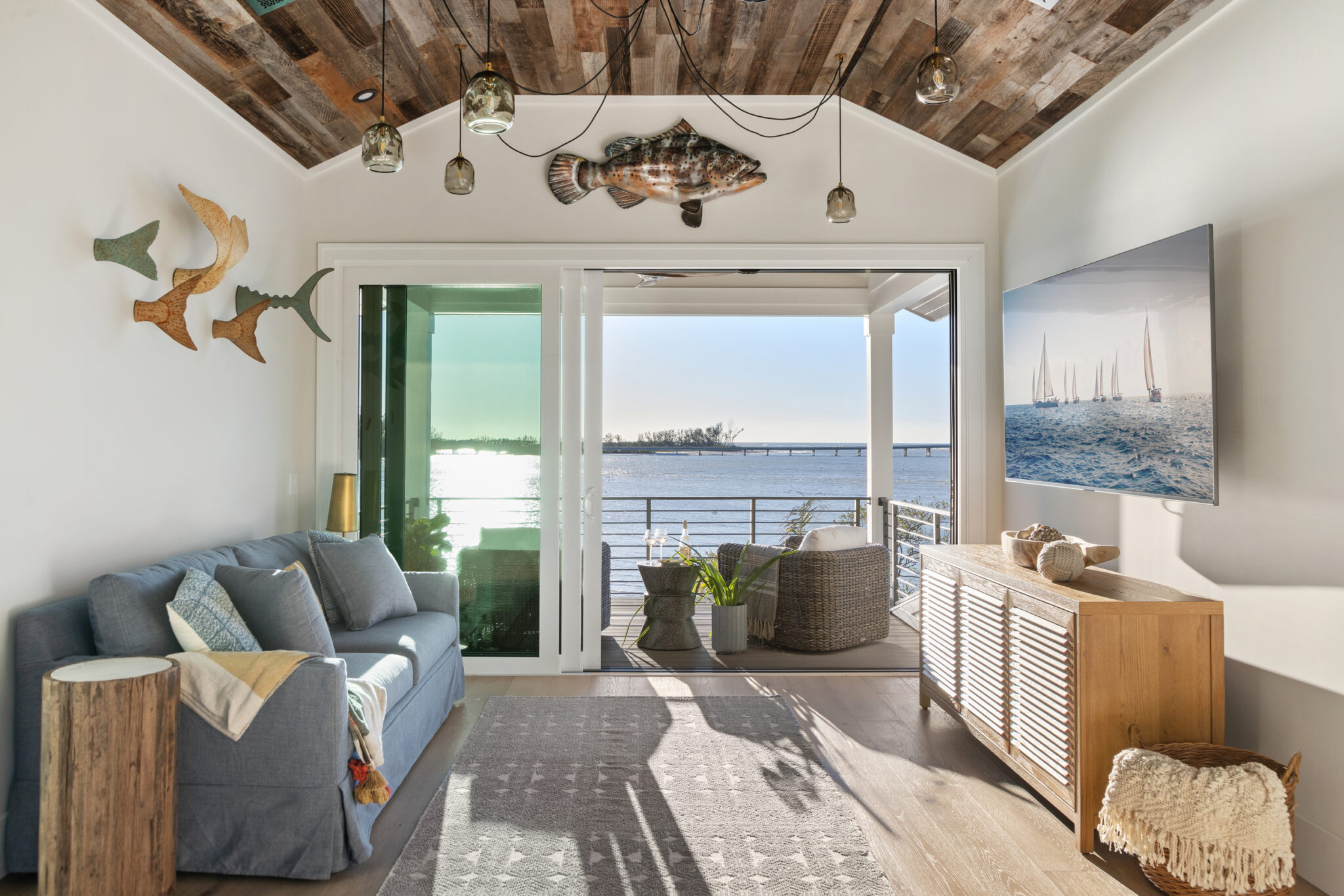 Den with a blue sofa, fish wall art and a reclaimed-wood ceiling