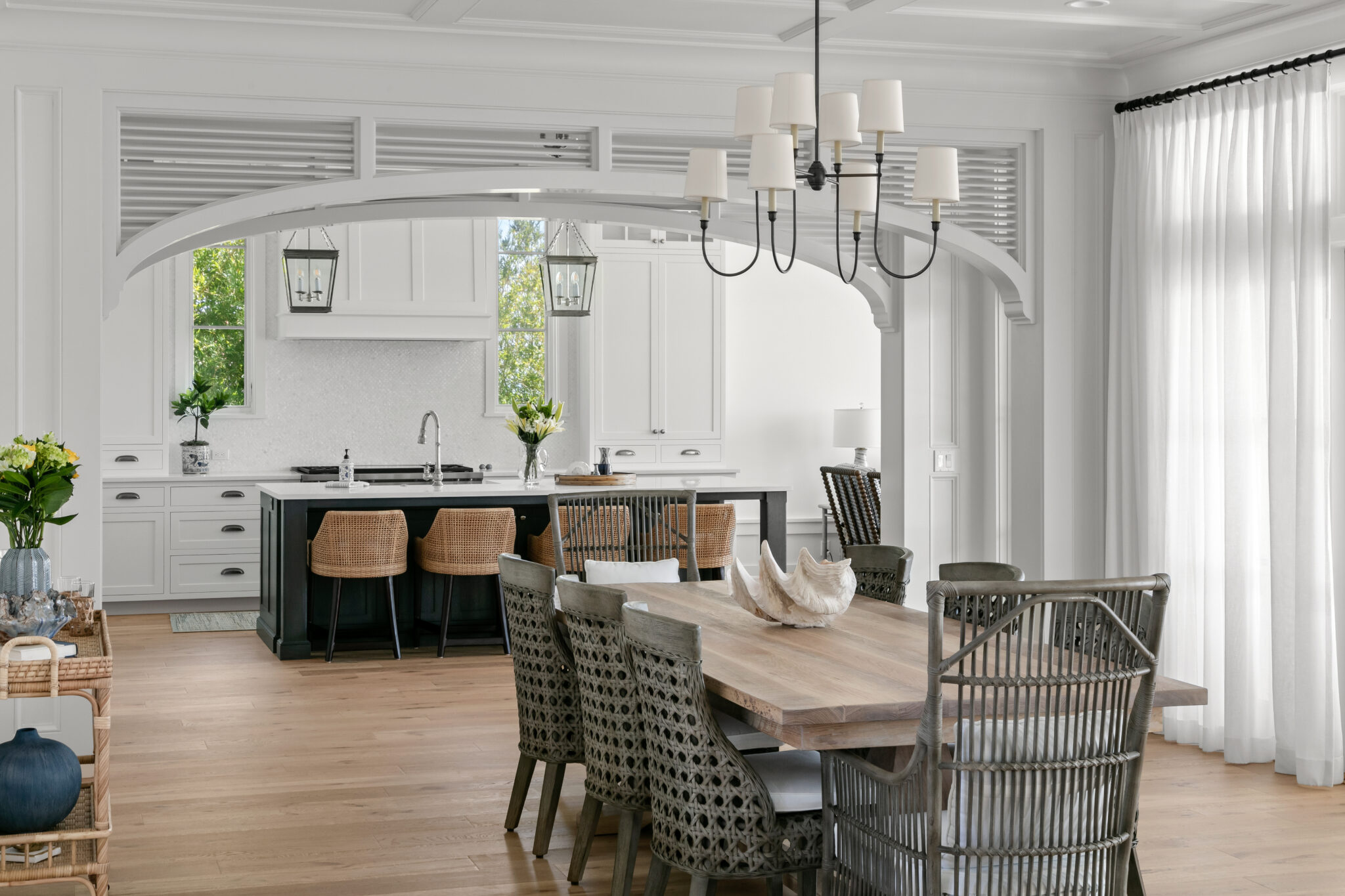 Dining area with an arched opening to the kitchen and black island