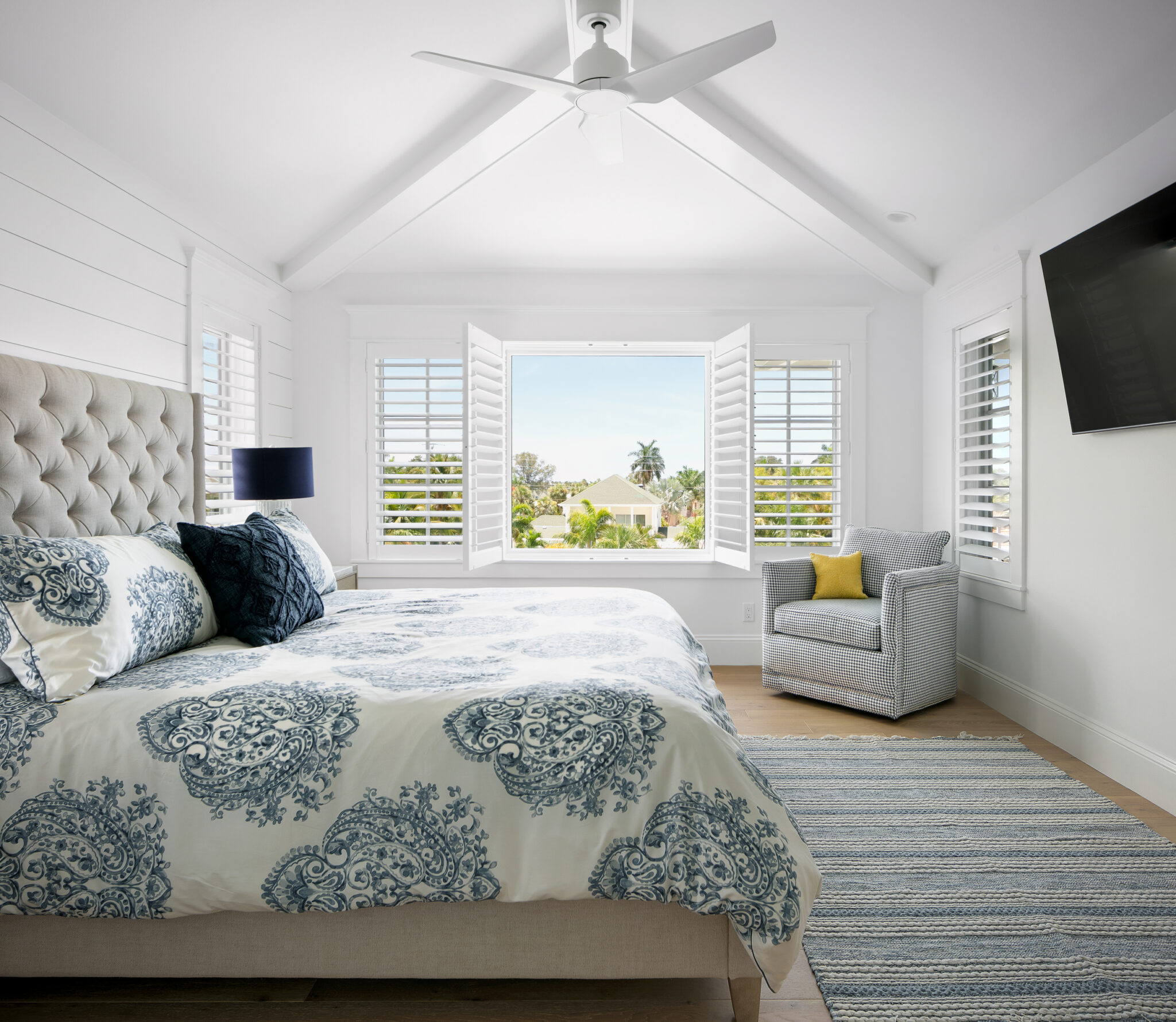 Bedroom with a tufted headboard under a vaulted ceiling