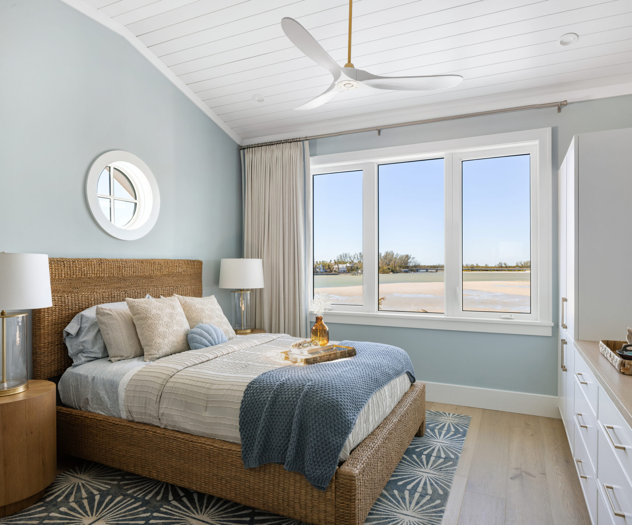 Bedroom with a woven headboard and round window