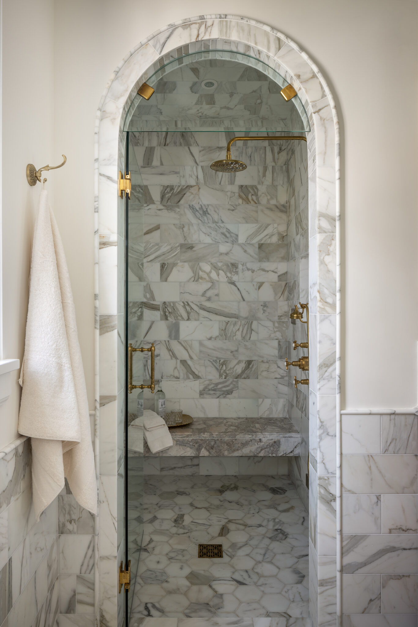 Arched marble shower with brass fixtures