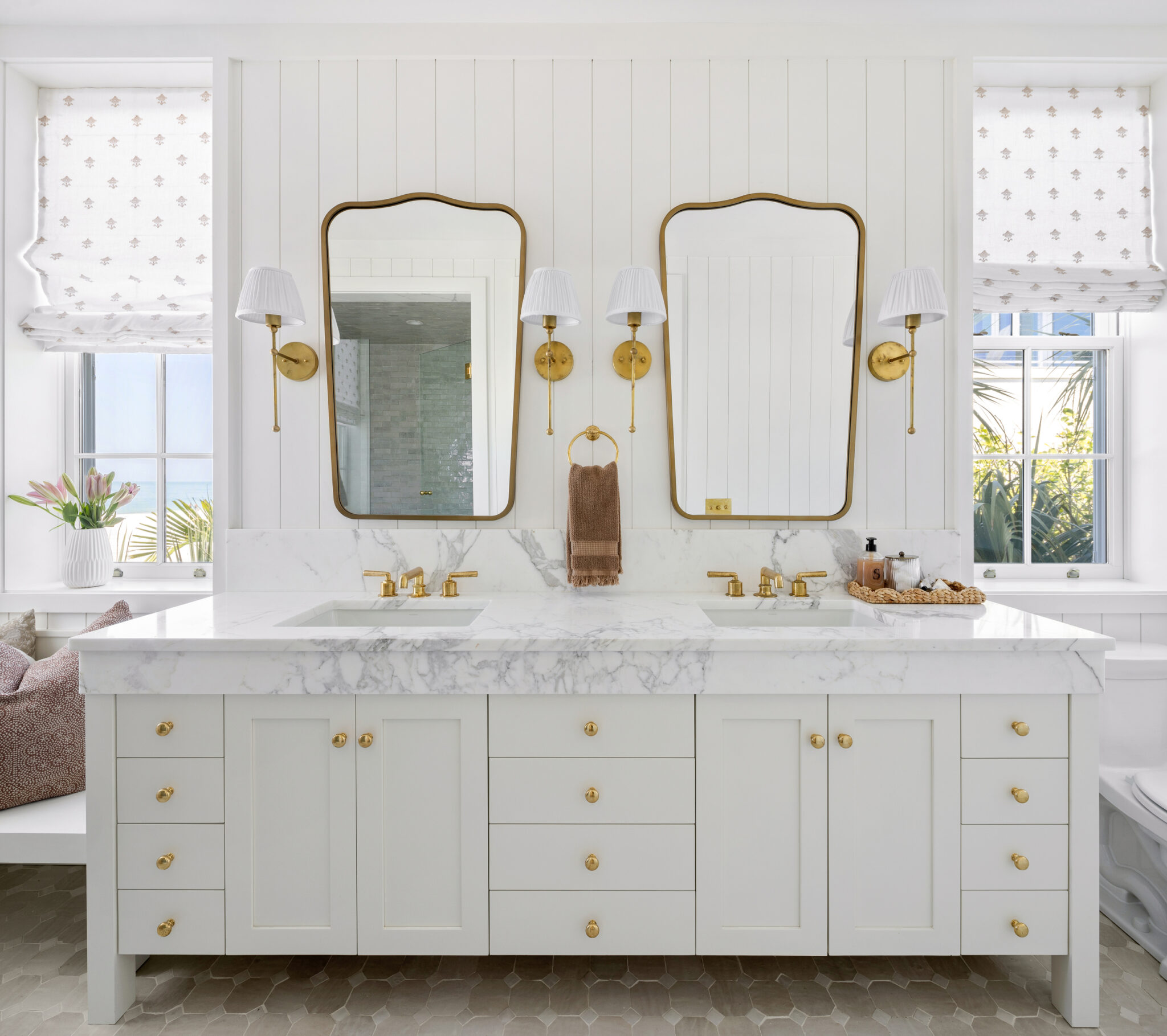 Double vanity with brass mirrors and sconces