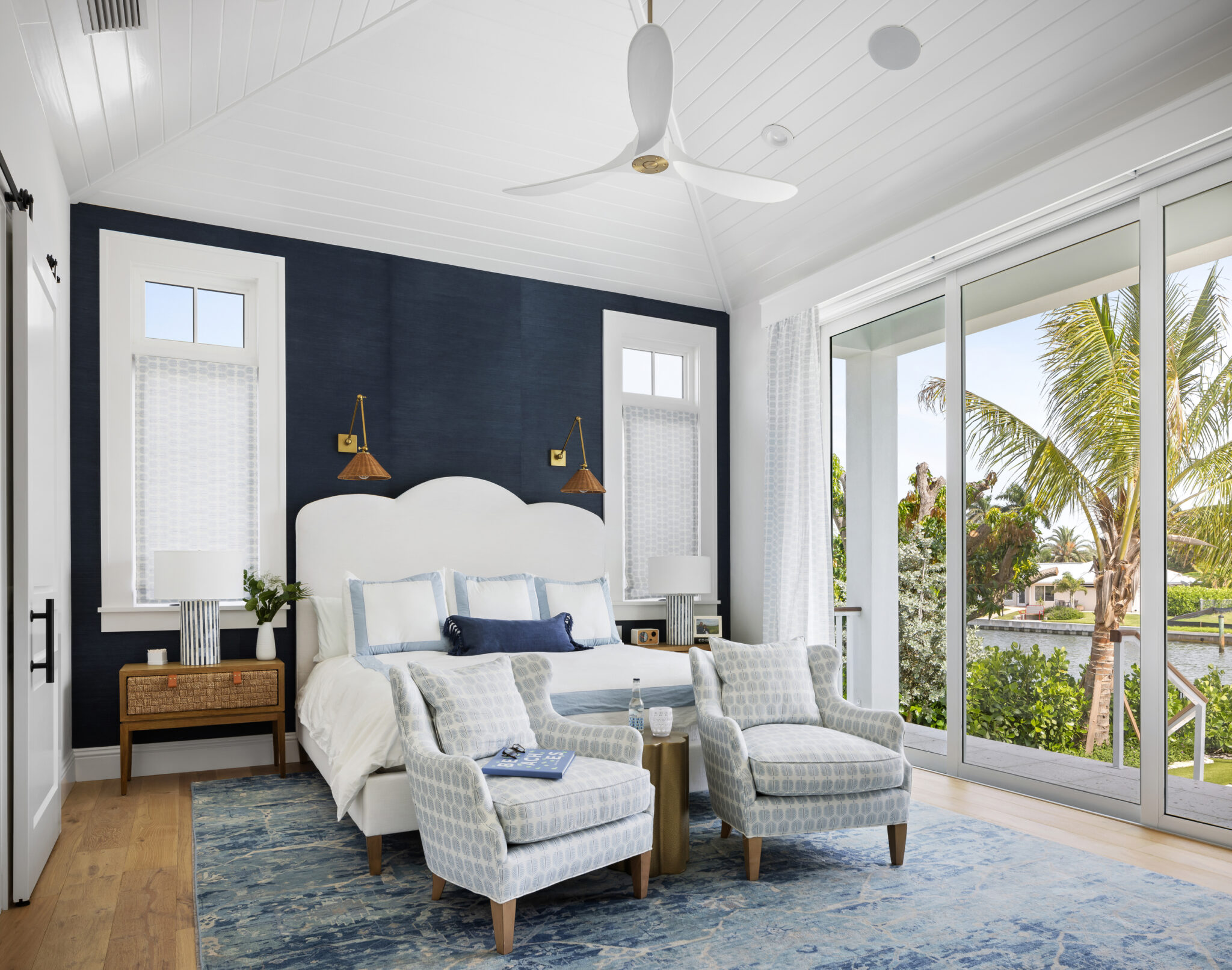 Bedroom with a navy accent wall and sliding doors to the pool