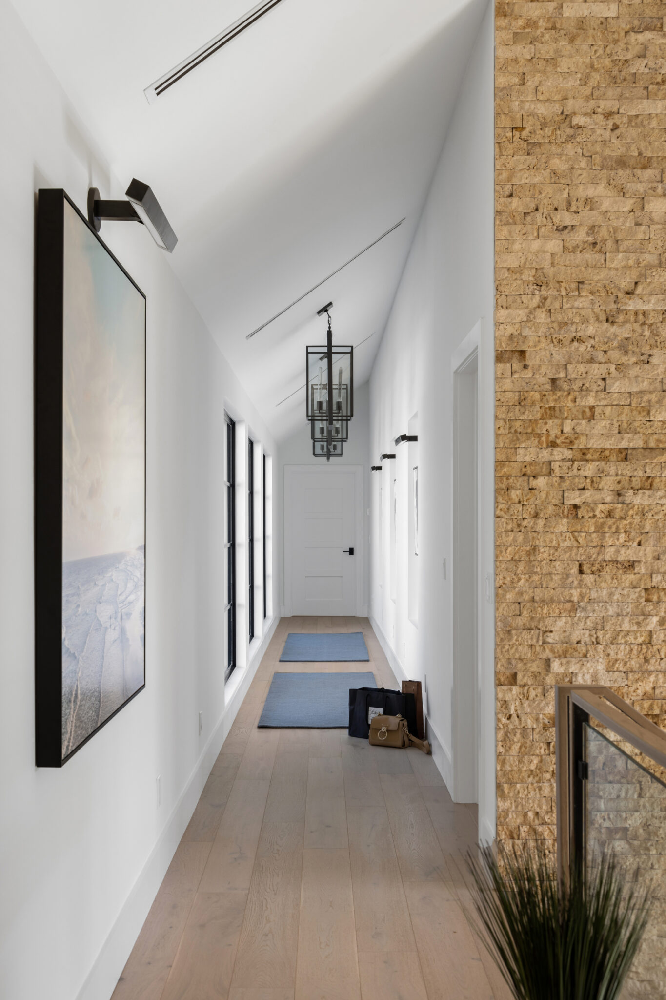 Upstairs hall with a stone wall and art